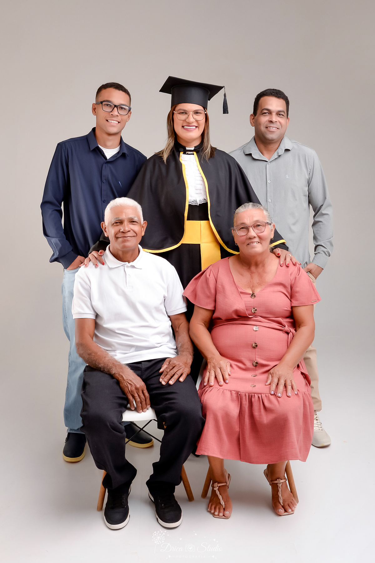 fotos formando - fotos em studio - radiologia - formatura - drica studio - foto em familia - formanda, com o marido e filho e com os pais - os pais da formanda sentados - formanda com sua familia em pé prestigiando os pais 