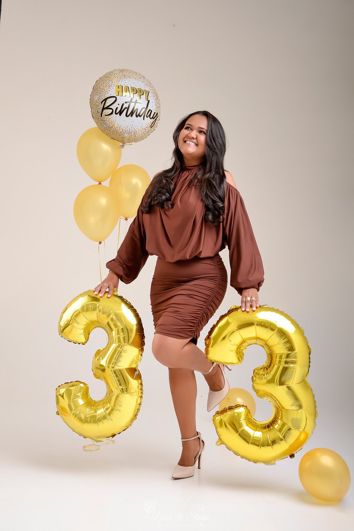 Aniversário - 33Anos - HappyBirthday - EnsaioFeminino -  EnsaioDeAniversário - aniversariante usando vestido marrom - com balões de 33 anos - balões dourados - fundo branco 