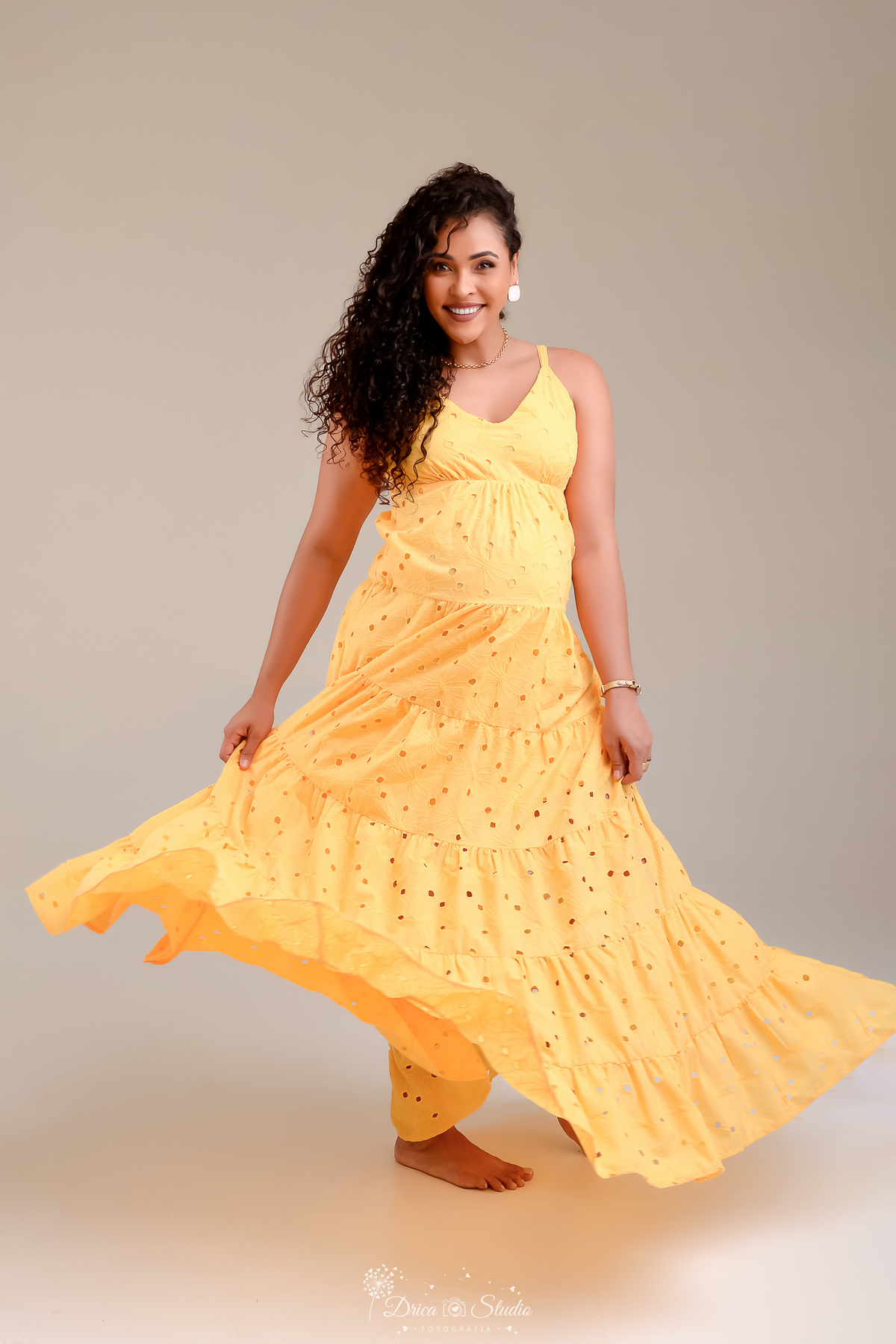 drica studio - ensaio gestante - mamãe de segunda viagem - usando vestido amarelo - rodando o vestido - fundo branco 