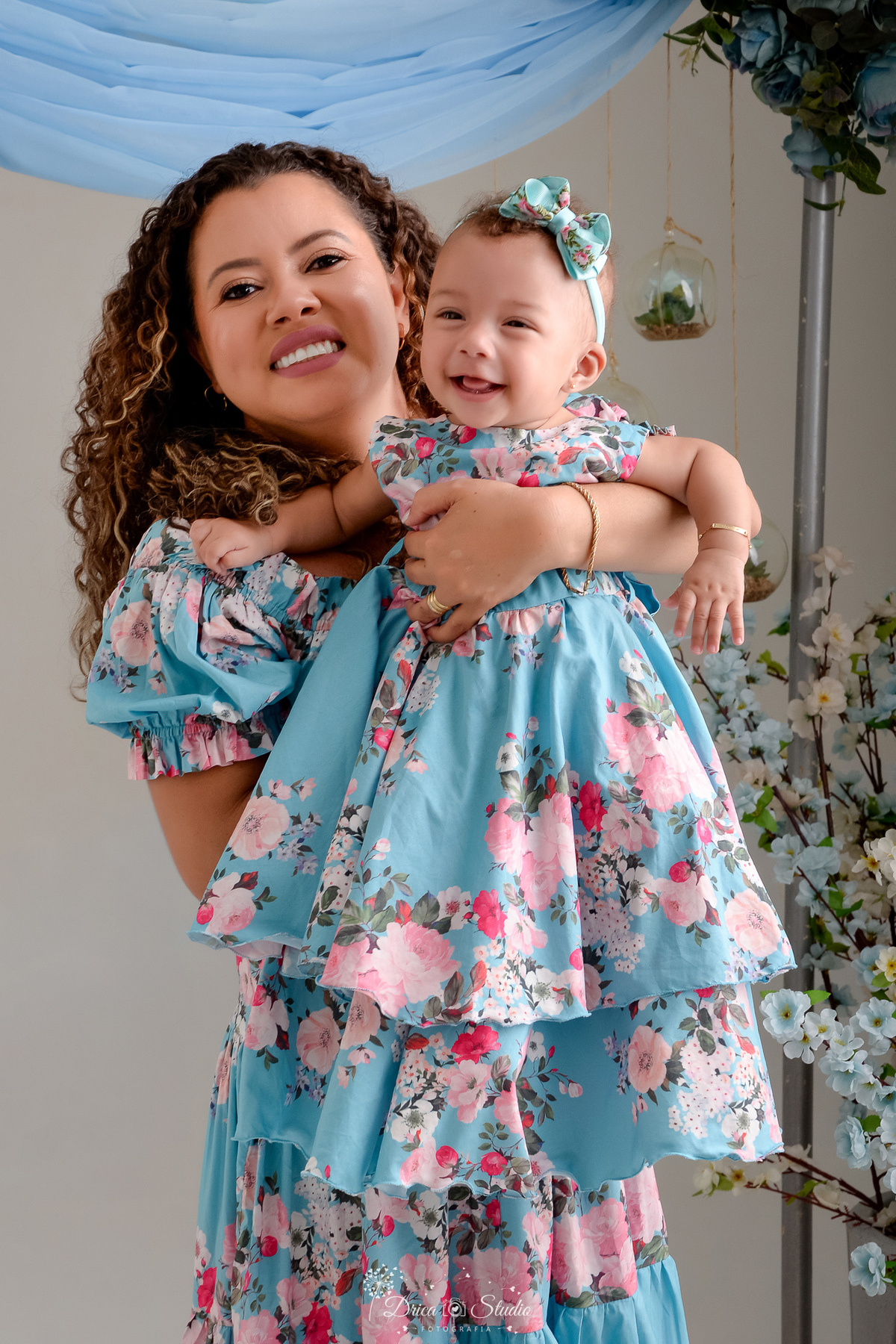 Ensaio mãe e filha - amor incondicional - mãe e filha usando roupas iguais - no tom azul e rosa - ao fundo flores azuis  - 