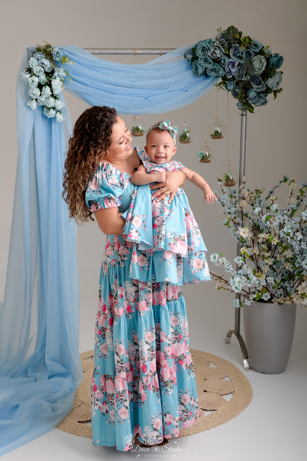 Ensaio mãe e filha - amor incondicional - mãe e filha usando roupas iguais - no tom azul e rosa - ao fundo flores azuis - 