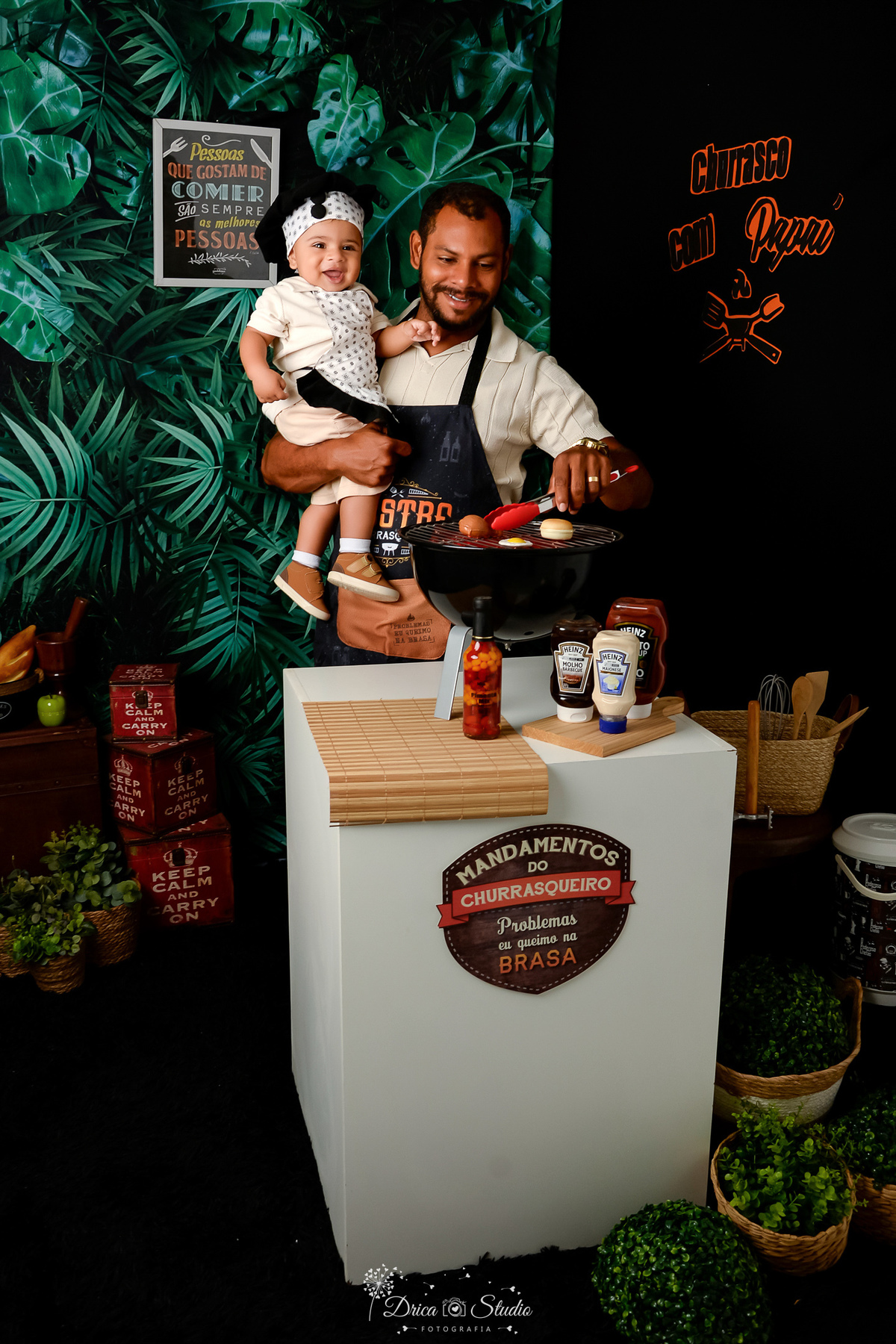 churrasco com o papai - pai e filho - cenário de dia dos pais - cenário com churrasqueira - Molhos de churrasco - pai e filho usando avental de churrasco - fundo com folhagem verde - acompanhamento mensal - 