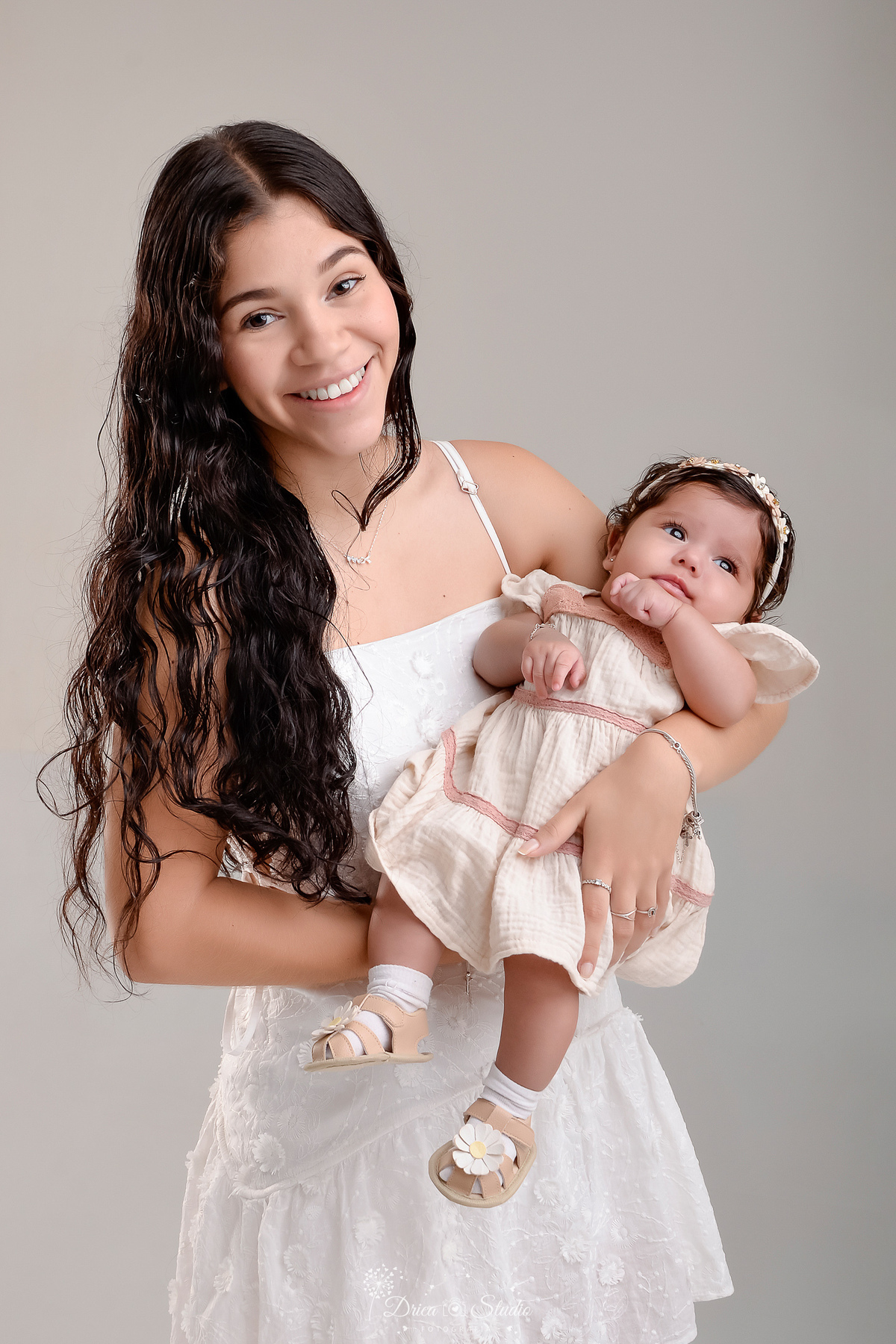 mãe e filha - acompanhamento mensal - fotos em estúdio - drica studio - xinguara - pará - mãe usando vestido branco - segurando sua bebê nos braços - fundo branco -