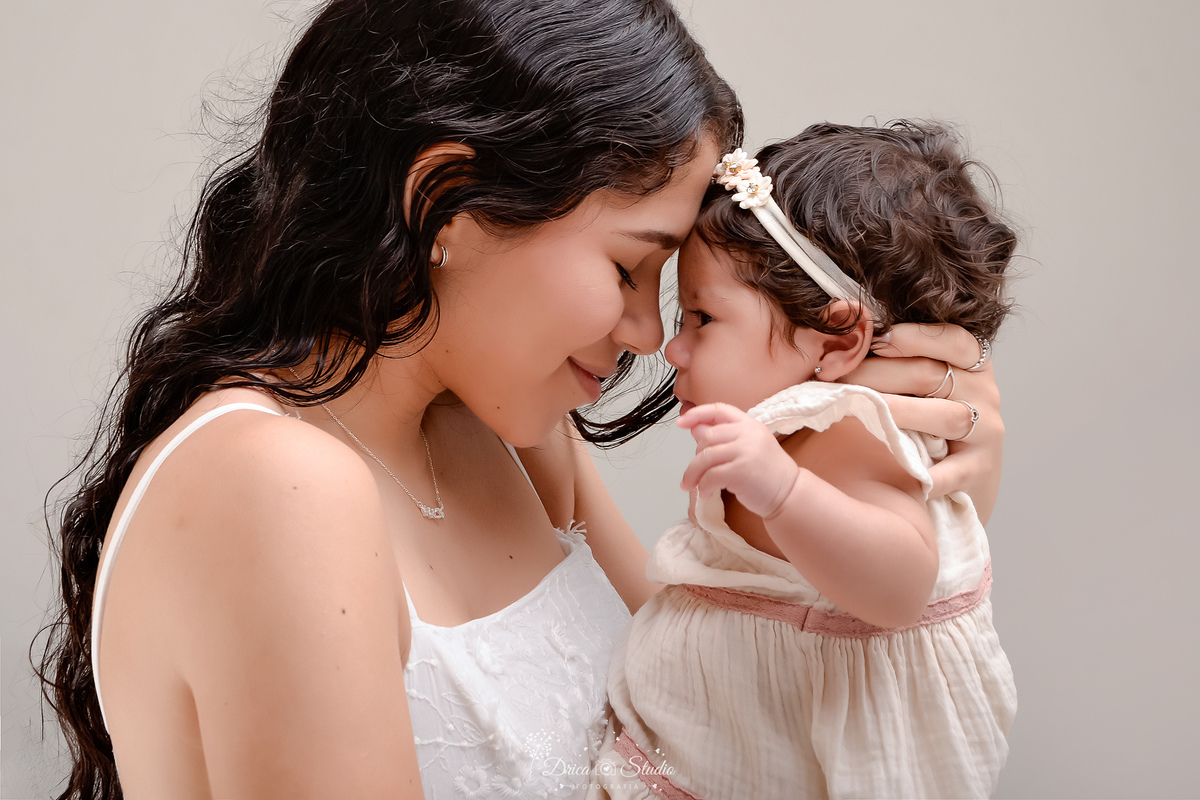 mãe e filha - acompanhamento mensal - fotos em estúdio - drica studio - xinguara - pará - mãe usando vestido branco - filha usando vestido bege - mãe e filha abraçadas 