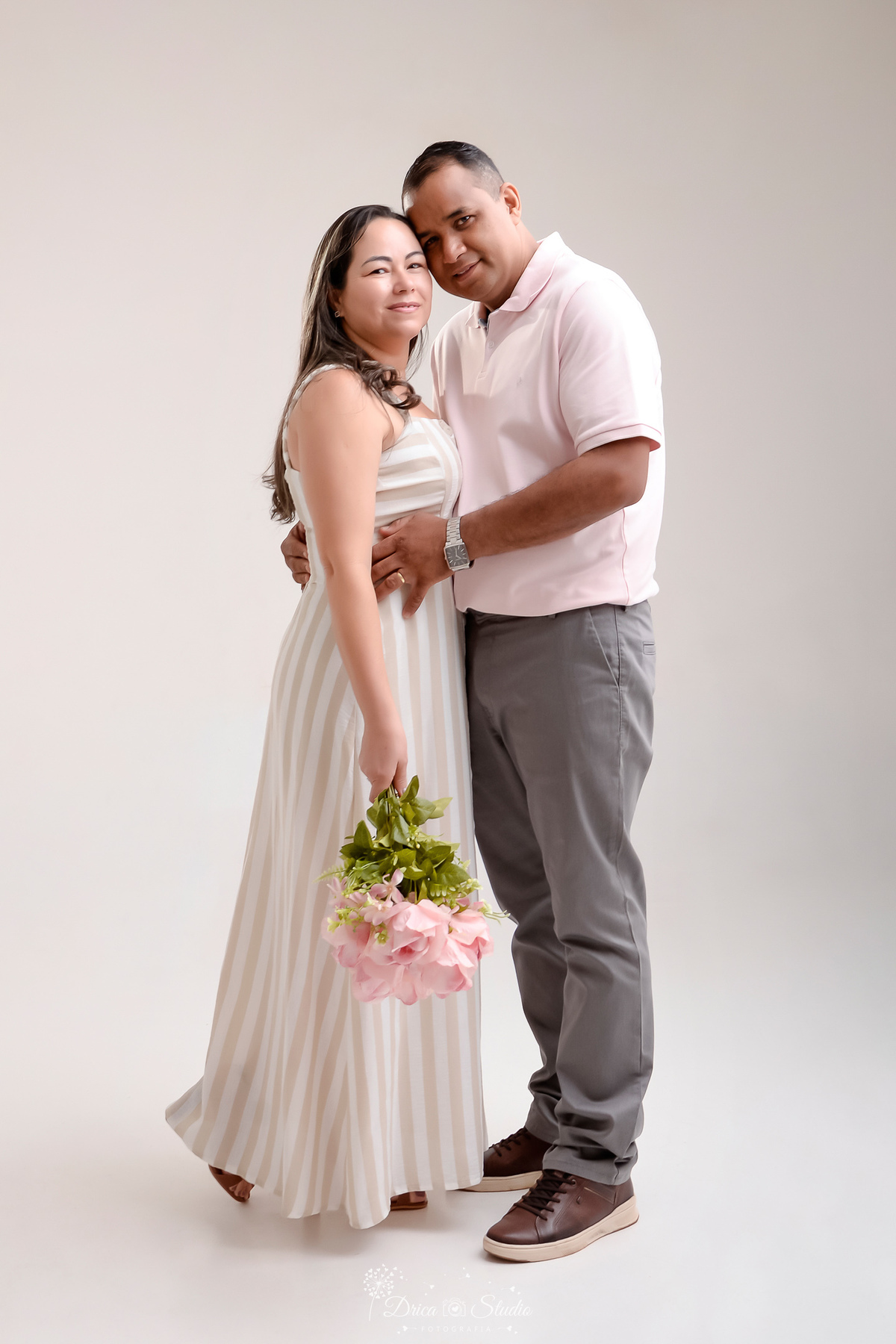 prewedding - ensaio casal - noivos - casamento - ensaio em estudio - drica studio - xinguara - pará - noivos abraçados - noiva segurando um buque de rosas - foto em fundo branco - noiva usando vestido longo - 