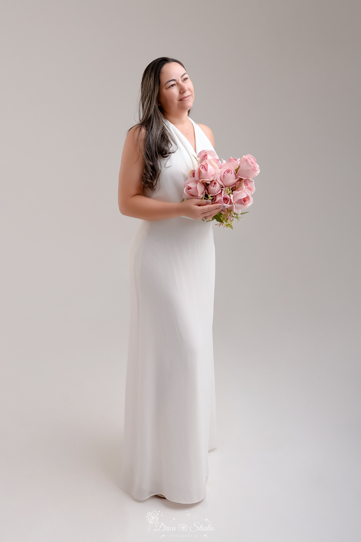 prewedding - ensaio casal - noivos - casamento - ensaio em estudio - drica studio - xinguara - pará - noiva usando vestido longo branco - segurando boque de rosas - foto em fundo brando - 