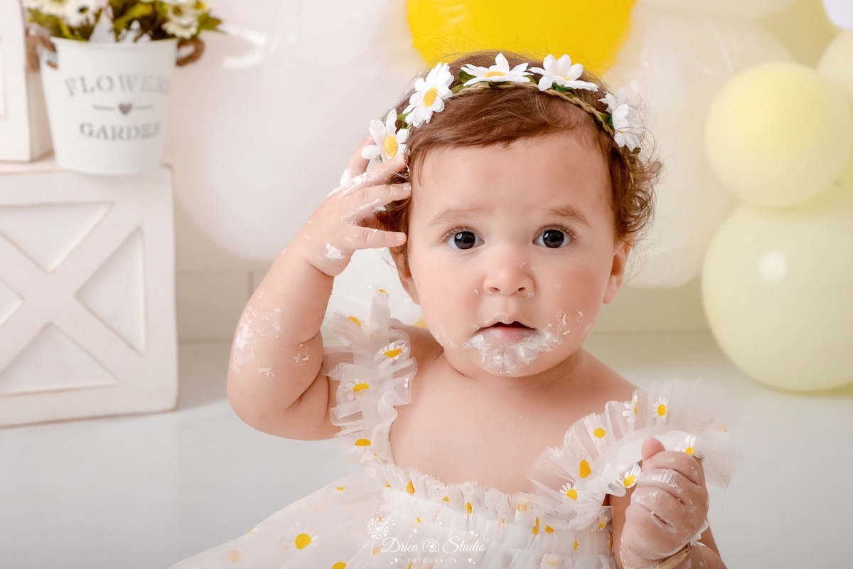 drica studio - smash the cake - 1 aninho - fim de acompanhamento mensal - bebe usando tiara de margarida - vestido branco de margarida -  