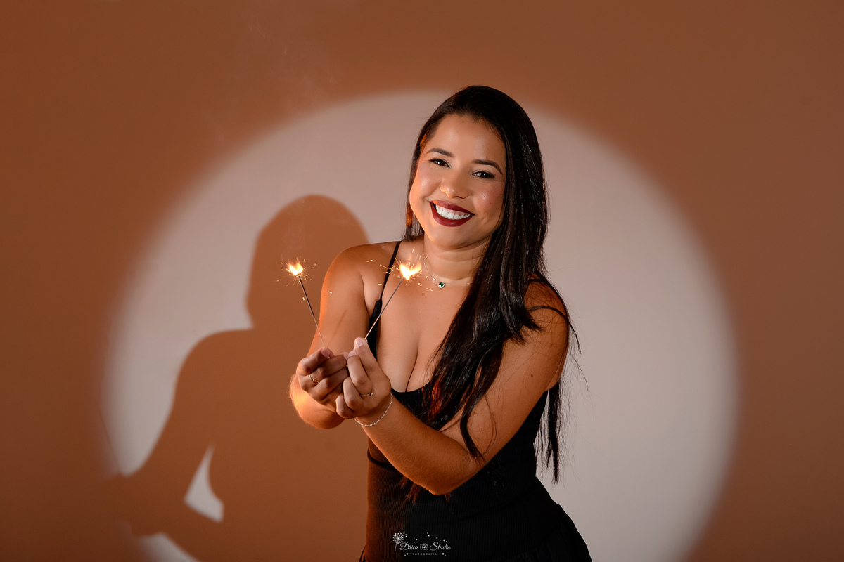 ensaio de aniversario - fotos de 30 anos - ensaio em estudio - drica studio - xinguara - pará - luz de fundo - segurando velinhas de faiscas - usando vestido preto - 