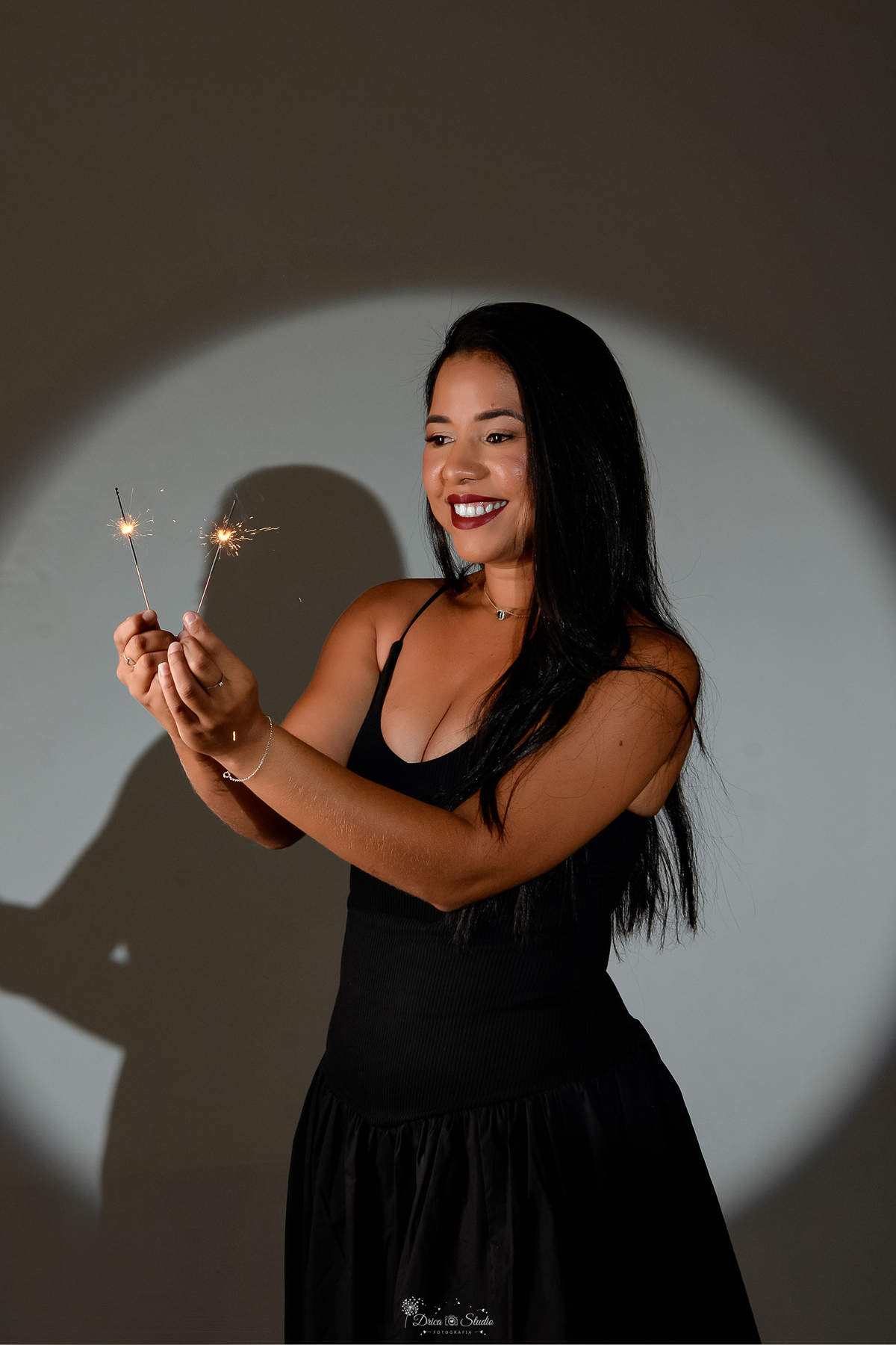 ensaio de aniversario - fotos de 30 anos - ensaio em estudio - drica studio - xinguara - pará - luz de fundo - segurando velinhas de faiscas - usando vestido preto - 