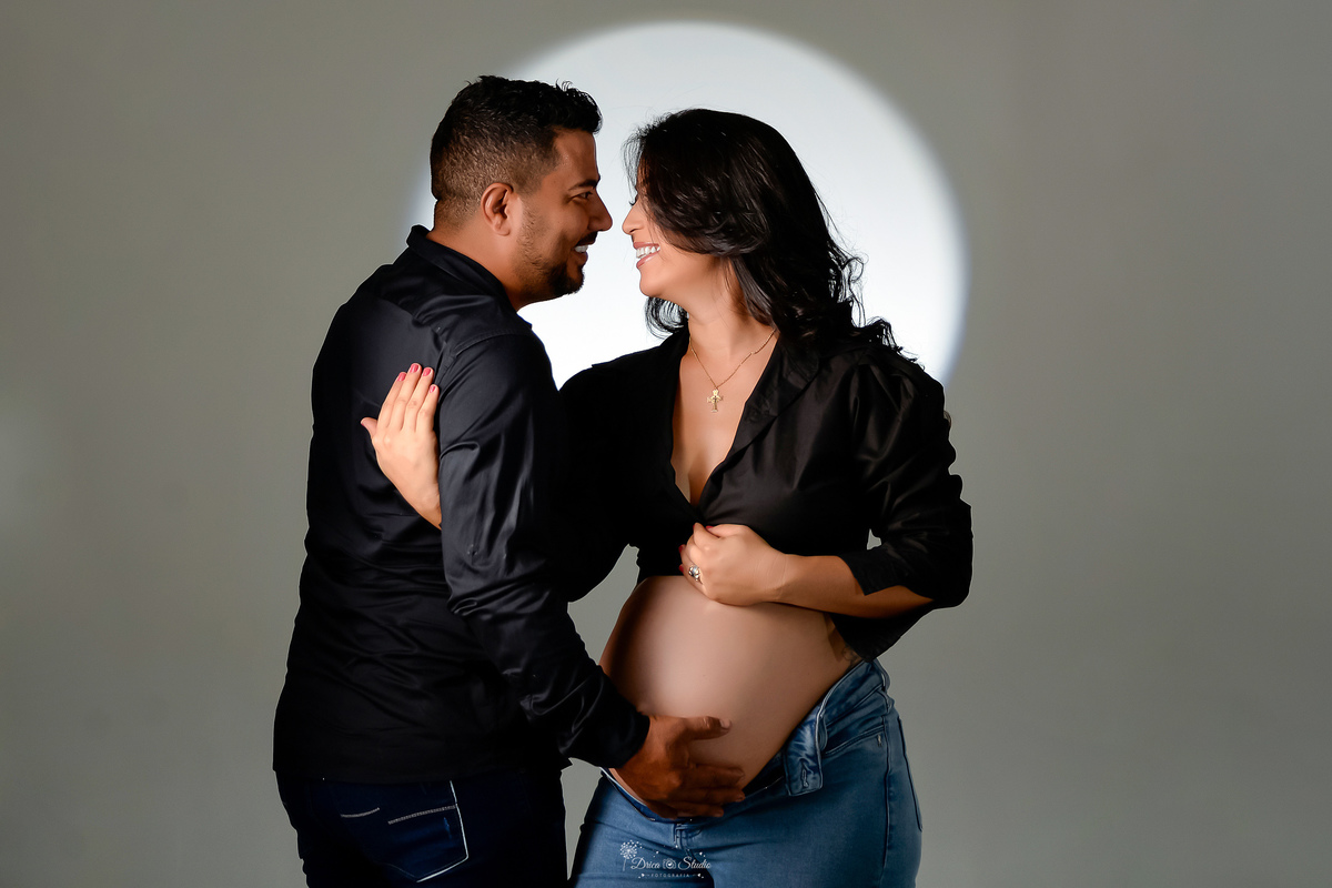 -ensaiogestante -fotografiagestante  -gravidez -maternidade - casal usando look preto - calça jeans e blusa preta - pai com a mão na barriga da mãe - 