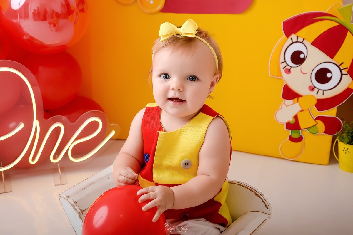 drica studio - smash the cake - 1 ano - ensaio infantil - acompanhamento mensal - xinguara - pará -  bebe segurando balão vermelho - usando roupa da emilia fundo amarelo 