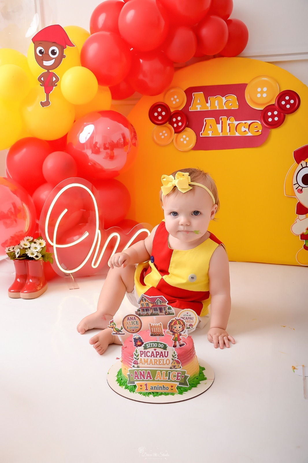 drica studio - smash the cake - 1 ano - ensaio infantil - acompanhamento mensal - xinguara - pará - cenário de emilia - balões vermelhos e amarelos - bebe usando roupa de emilia com laço amarelo - bolo 