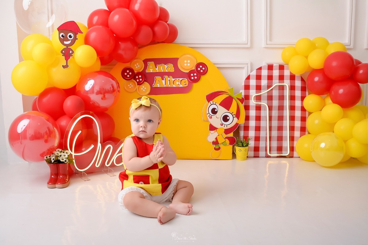 drica studio - smash the cake - 1 ano - ensaio infantil - acompanhamento mensal - xinguara - pará - cenário tema emilia - balões vermelhos e amarelos - one de led - 1 de led - bebe usando roupinha de emilia - com laço amarelo 