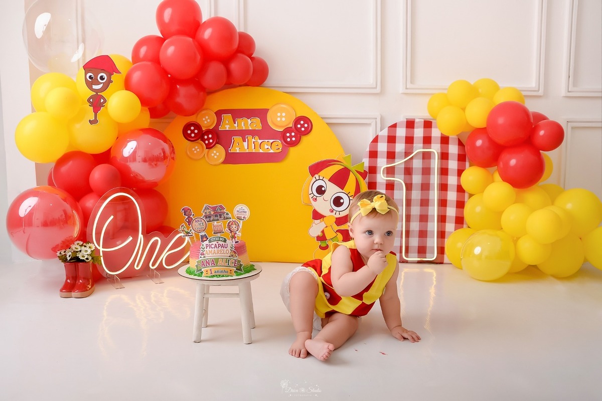 drica studio - smash the cake - 1 ano - ensaio infantil - acompanhamento mensal - xinguara - pará - cenário de emilia - balões amarelos e vermelhos - bolo com topos da emilia - bebe usando roupinha da emilia - saci - 