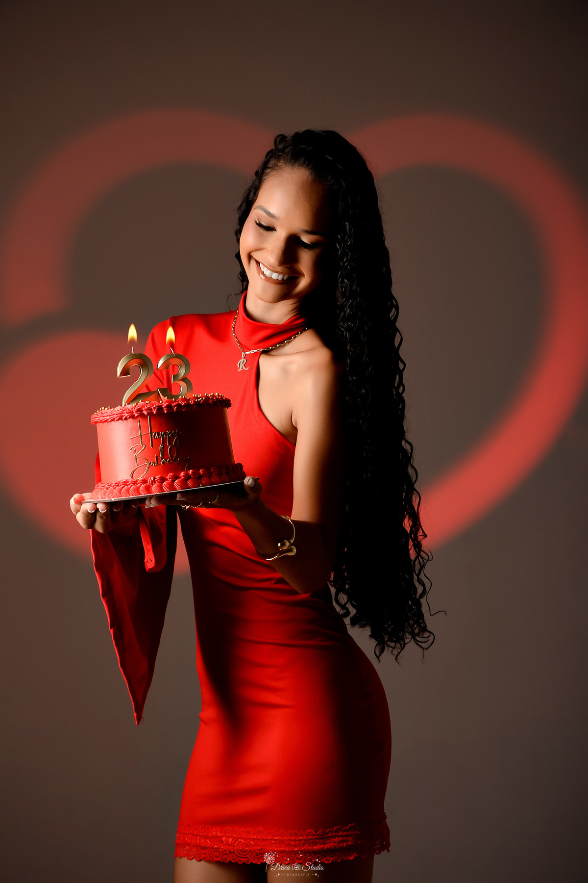 drica studio - ensaio de aniversário - fotos em estudio - 23 anos - ensaio feminino - usando vestido vermelho - com velas de numero 23 - led com imagem de coração ao fundo - bolo vermelho - 