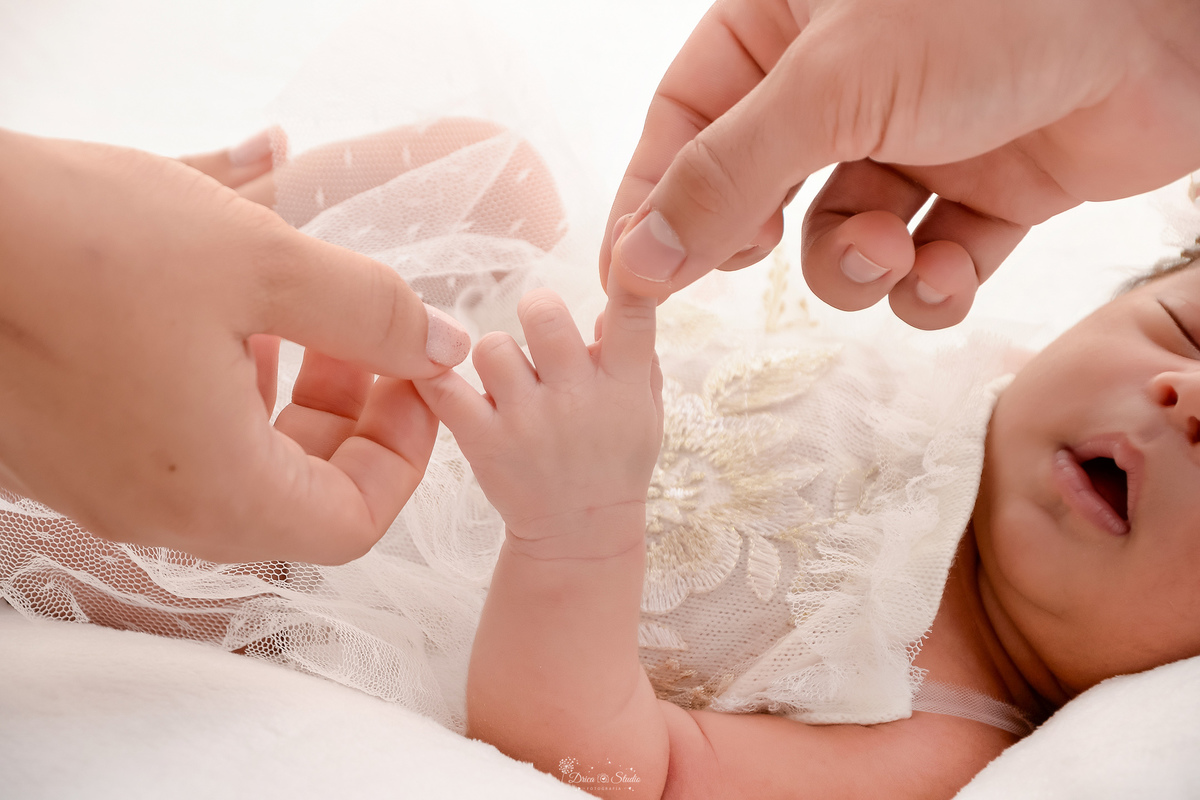 m nascida - ensaio newborn - ensaio famila - 18 dias de vida - babygril - drica studio - xinguara - pará - pai e mãe segurando o dedinho da filha 