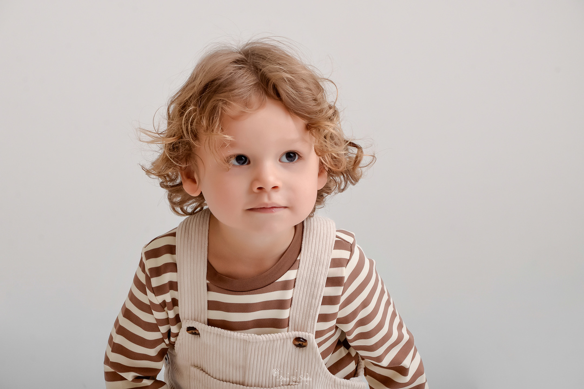 ensaio de aniversario - bebê de 2 anos - ensaio em estudio - drica studio - xinguara - pará - bebê abaixado - usando macacão bege com camisa listrada -  