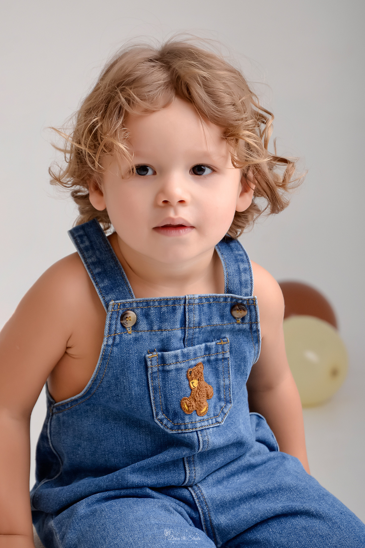 ensaio de aniversario - bebê de 2 anos - ensaio em estudio - drica studio - xinguara - pará - bebê usando macacão jeans - no chão balões marrom 