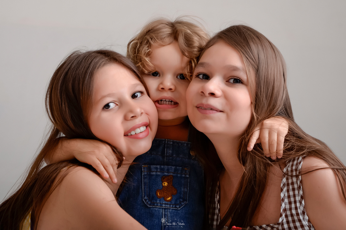 ensaio de aniversario - bebê de 2 anos - ensaio em estudio - drica studio - xinguara - pará - bebe abraçado nas duas irmãs mais velhas - fundo branco - 
