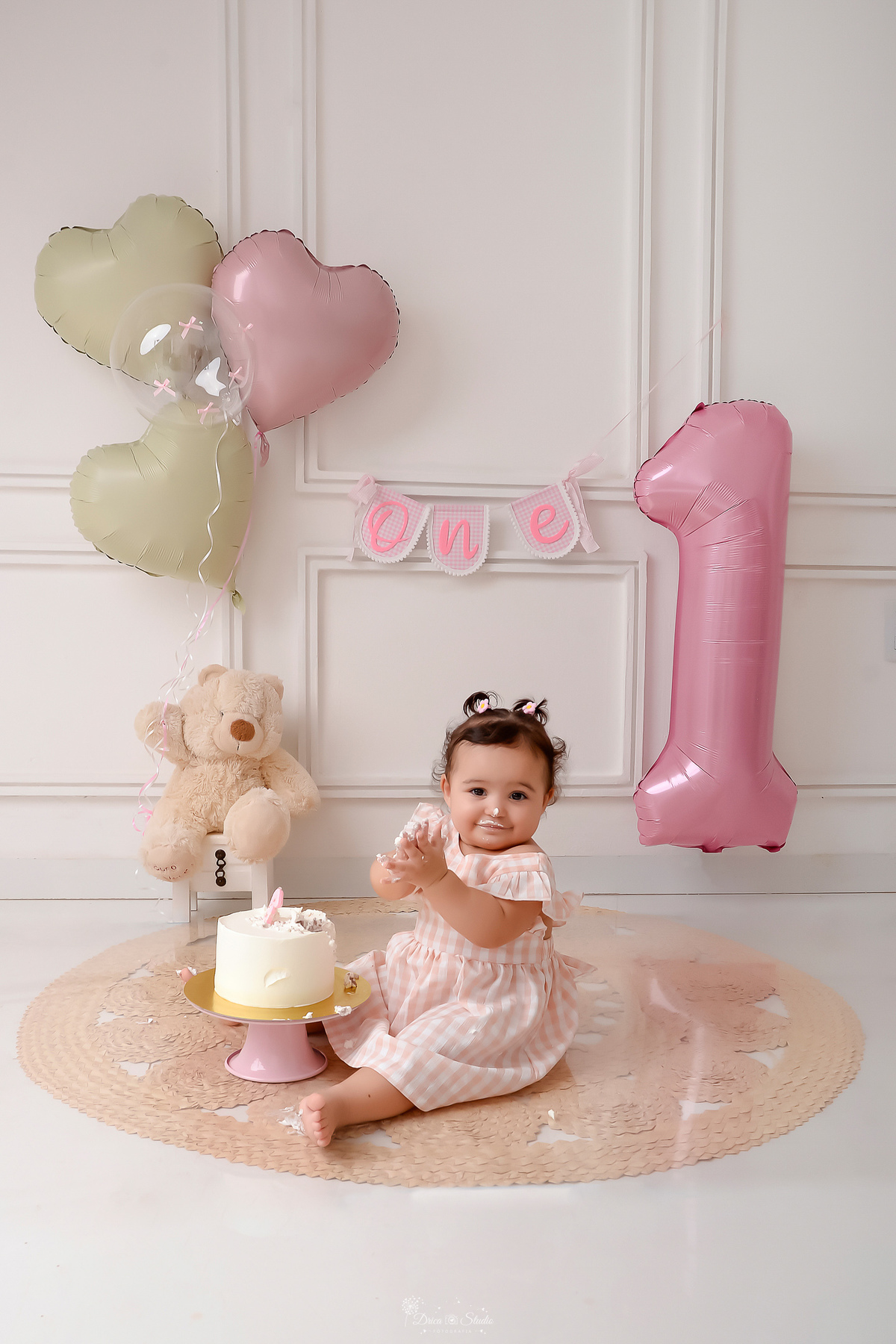 Drica studio - smash the cake - ensaio familia - 1 aninho - ensaio em estúdio - bebe batendo palmas - ursinho de pelucia segurando balões de coração - one na parede - bablão de numero 1 - bolo branco com vela de numero 1 - parede branca com detalhes - 