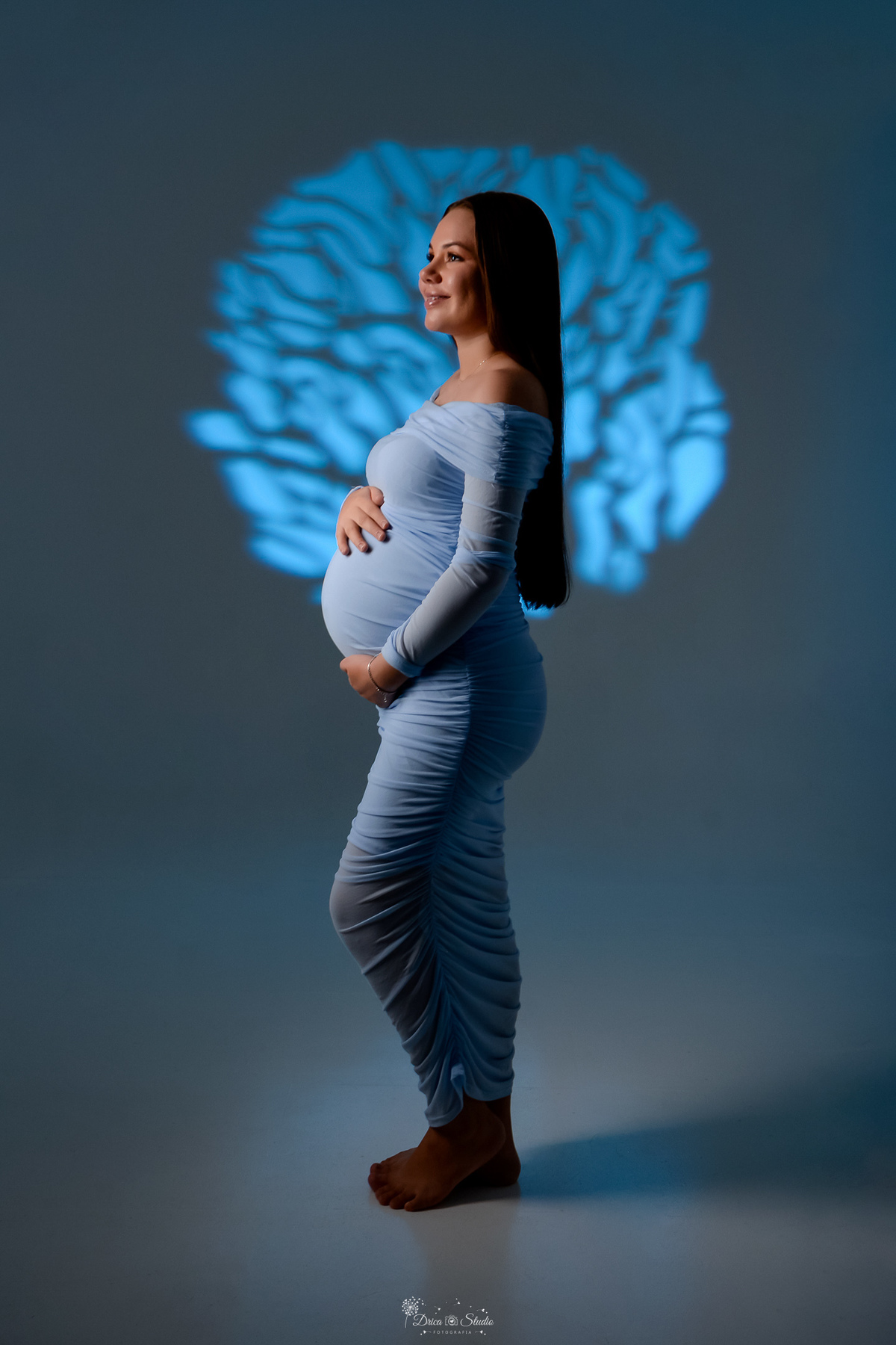 Ensaio gestante - ensaio em estudio - mamãe de primeira viagem - drica studio - xinguara - pará  mamãe usando vestido azul -  com as mãos na barriga - luz de fundo azul 