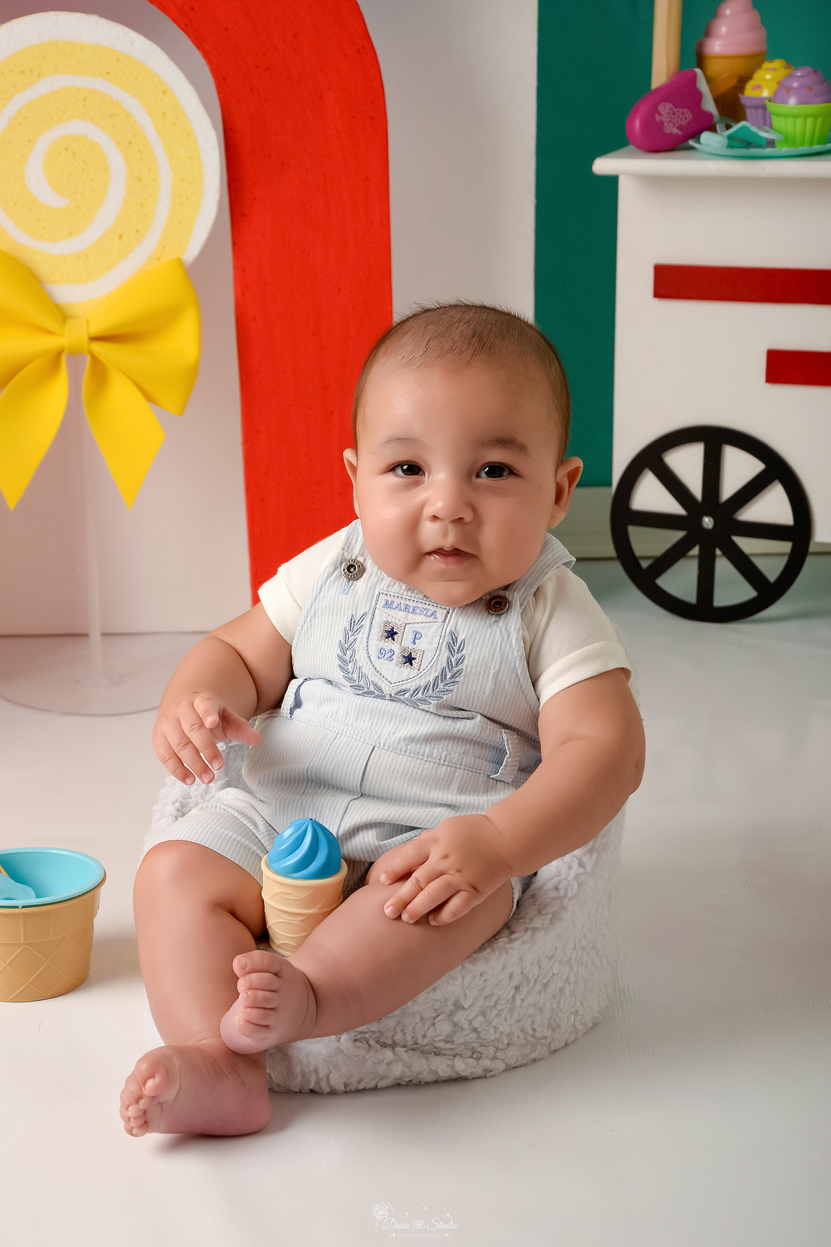 ompanhamento mensal - dia das crianças - cenário doce - mês das crianças - cenário com tematica doce - bebe sentado sobre sofazinho - com um sorvetinho de brinquedo 