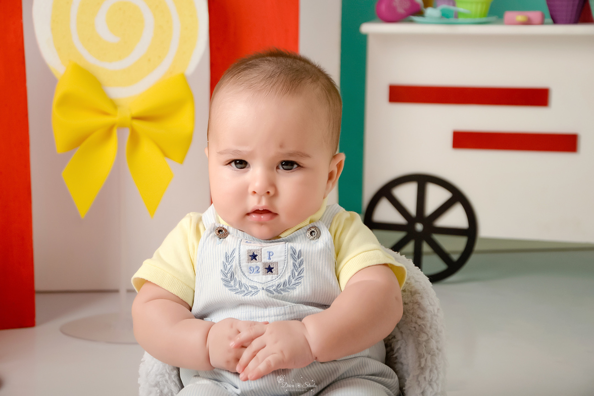 ompanhamento mensal - dia das crianças - cenário doce - mês das crianças - cenário com tematica doce - bebe sentada em um mini sofá 