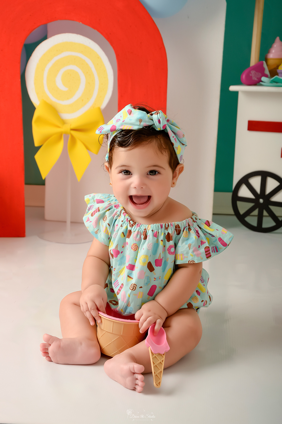 ompanhamento mensal - dia das crianças - cenário doce - mês das crianças - cenário com tematica doce - bebe sorrindo para a foto - usando roupinha com estampas de doce - e laço 