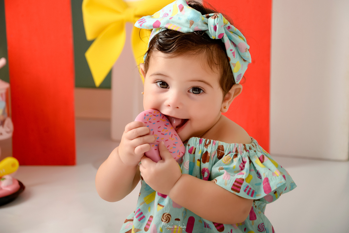 ompanhamento mensal - dia das crianças - cenário doce - mês das crianças - cenário com tematica doce - bebe com um picole rosa de brinquedo - usando bory com estampa de docinhos - 