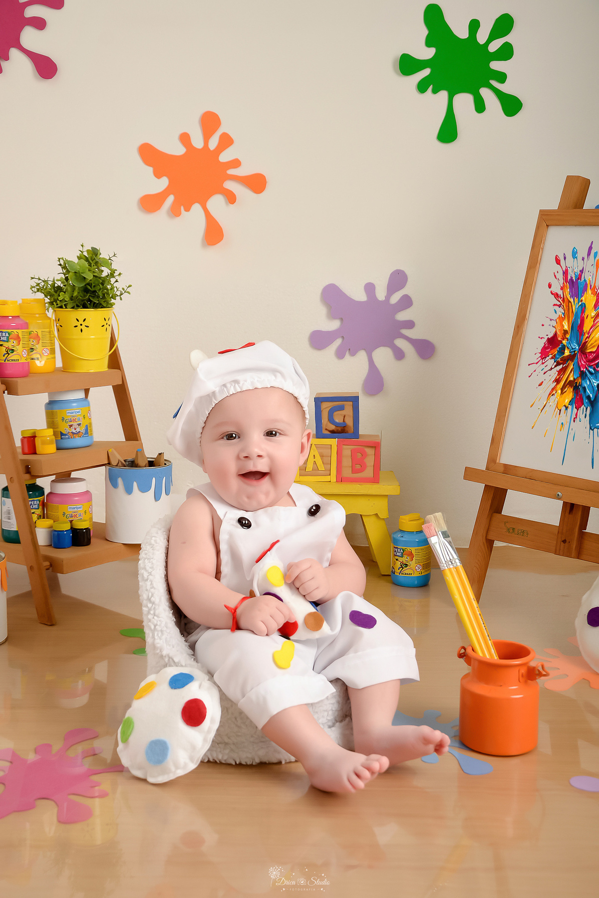 acompanhamento infantil - cenário de aquarela - dia das crianças - mês das crianças - cenários com latas de tintas - bebe usando roupinha de pintor - latas com pincéis - lousa  com pintura - bebe sentado em mini sofazinho - 