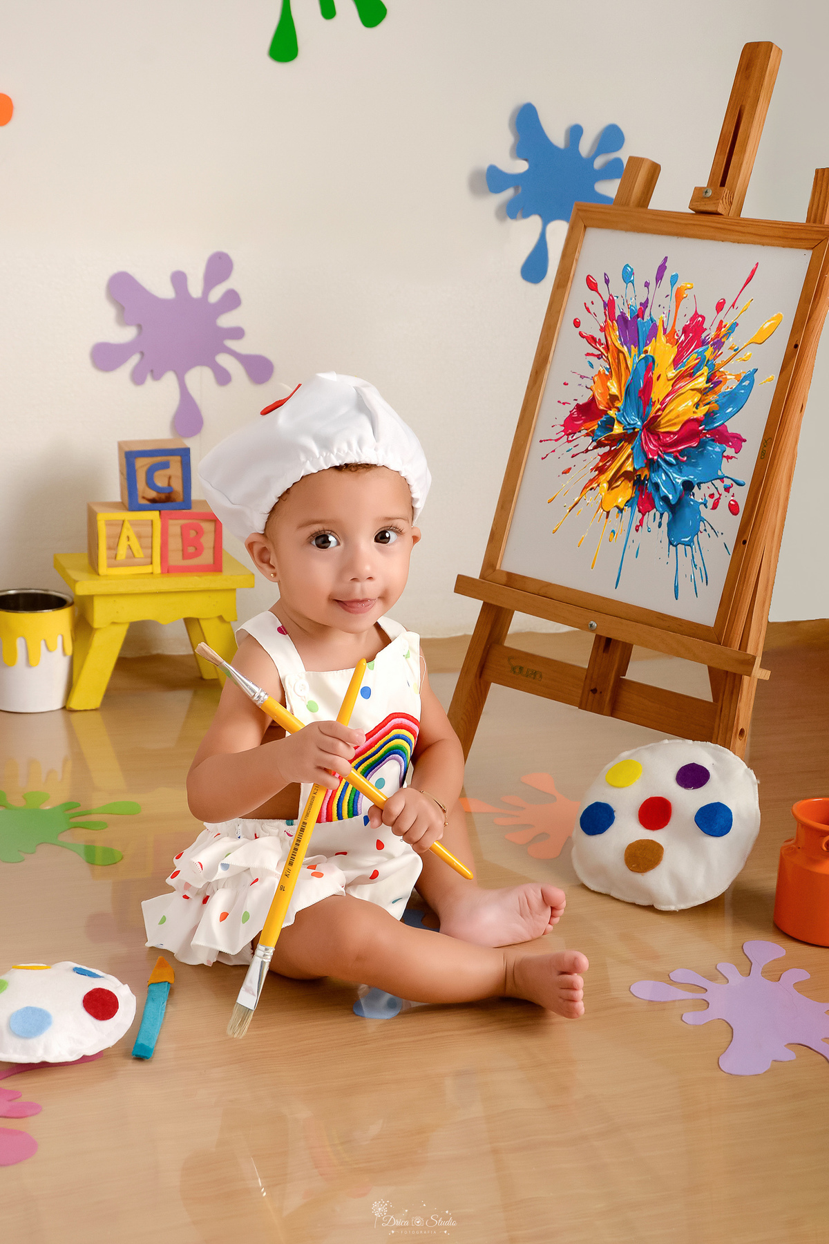 acompanhamento infantil - cenário de aquarela - dia das crianças - mês das crianças - cenários com latas de tintas - bebe usando roupa de pintora e gorrinho na cabeça - segurando pincéis                                                 