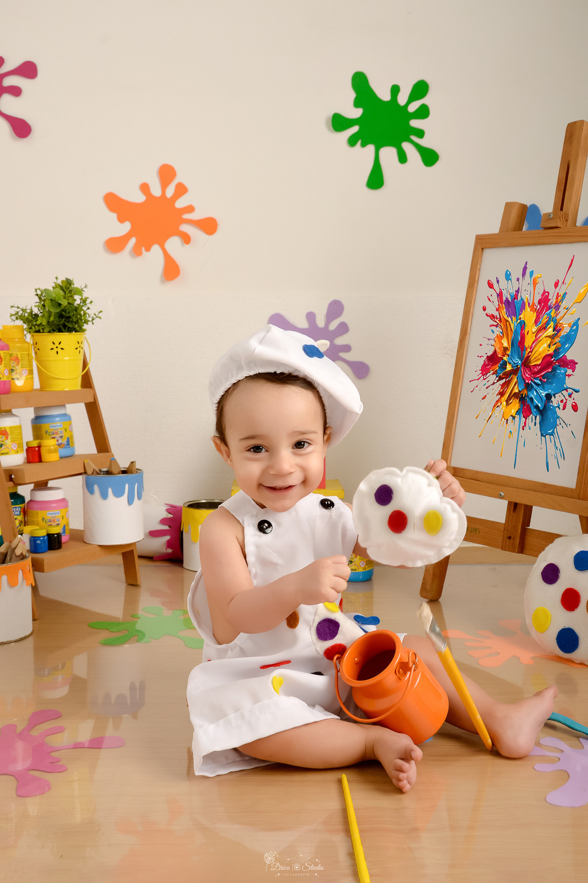 acompanhamento infantil - cenário de aquarela - dia das crianças - mês das crianças - cenários com latas de tintas - bebe usando roupinha de pintura - marcas de tintas coloridas pelo chão e pela parede - lousa com pintura 
