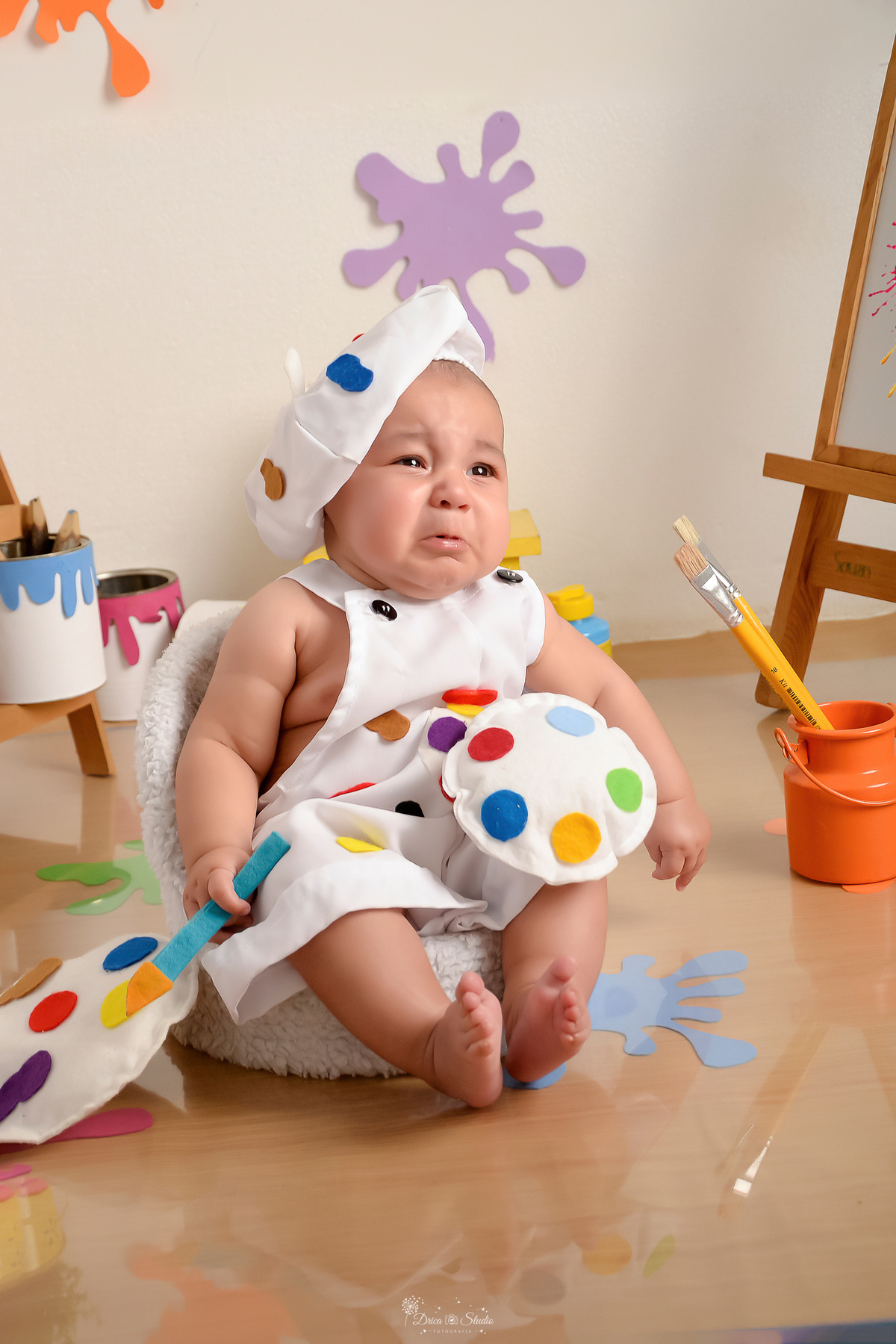 acompanhamento infantil - cenário de aquarela - dia das crianças - mês das crianças - cenários com latas de tintas - bebe usando roupinha de pintor e gorrinh na cabeça - lata com pincel ao lado - 