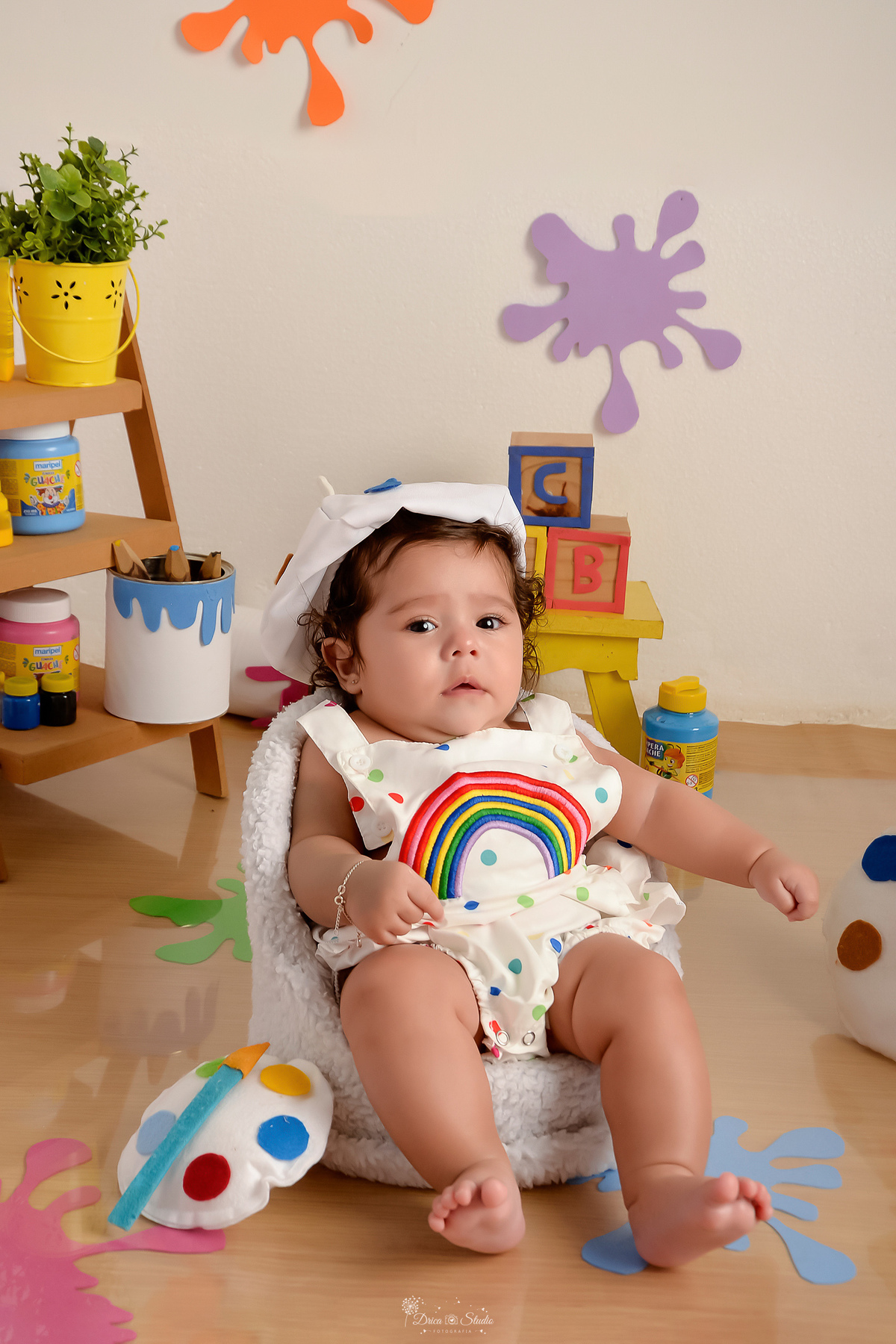 acompanhamento infantil - cenário de aquarela - dia das crianças - mês das crianças - cenários com latas de tintas - bebe usando roupinha de pintura e gorrinho na cabeça 