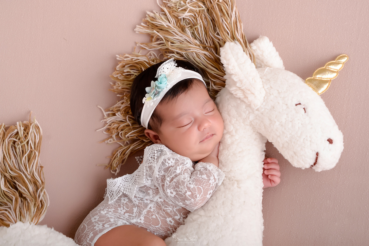 newborn - recém nascida - primeiros dias de vida - 11 dias de vida - menina - baby - em um mini unicórnio branco - usando bory branco - com tiara branca de flores - fotografia infantil - drica studio - xinguara - pará - 