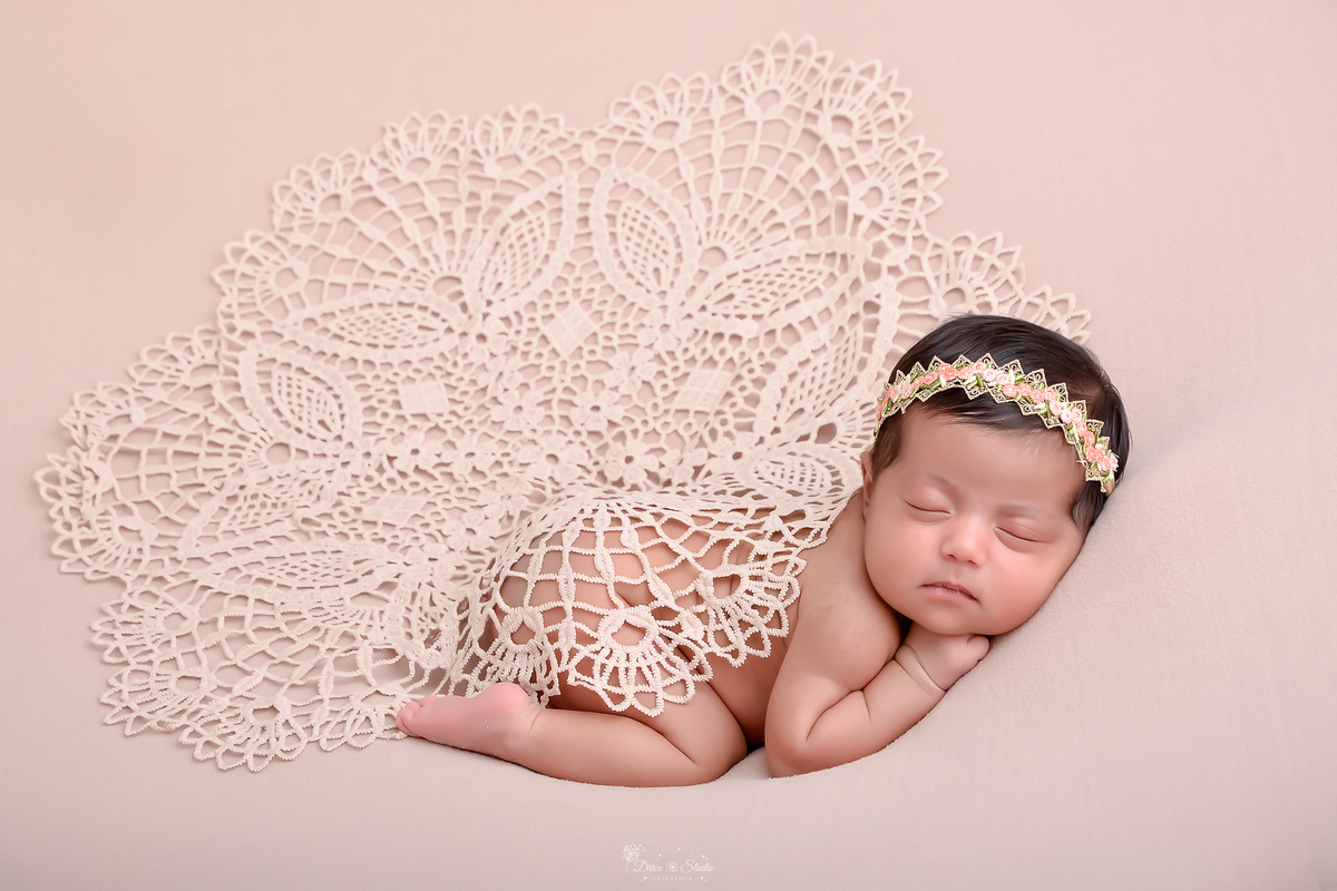 newborn - recém nascida - primeiros dias de vida - menina - baby - recordações - fotografia infantil - bebe deitada em tecido rosa - com tiara - 