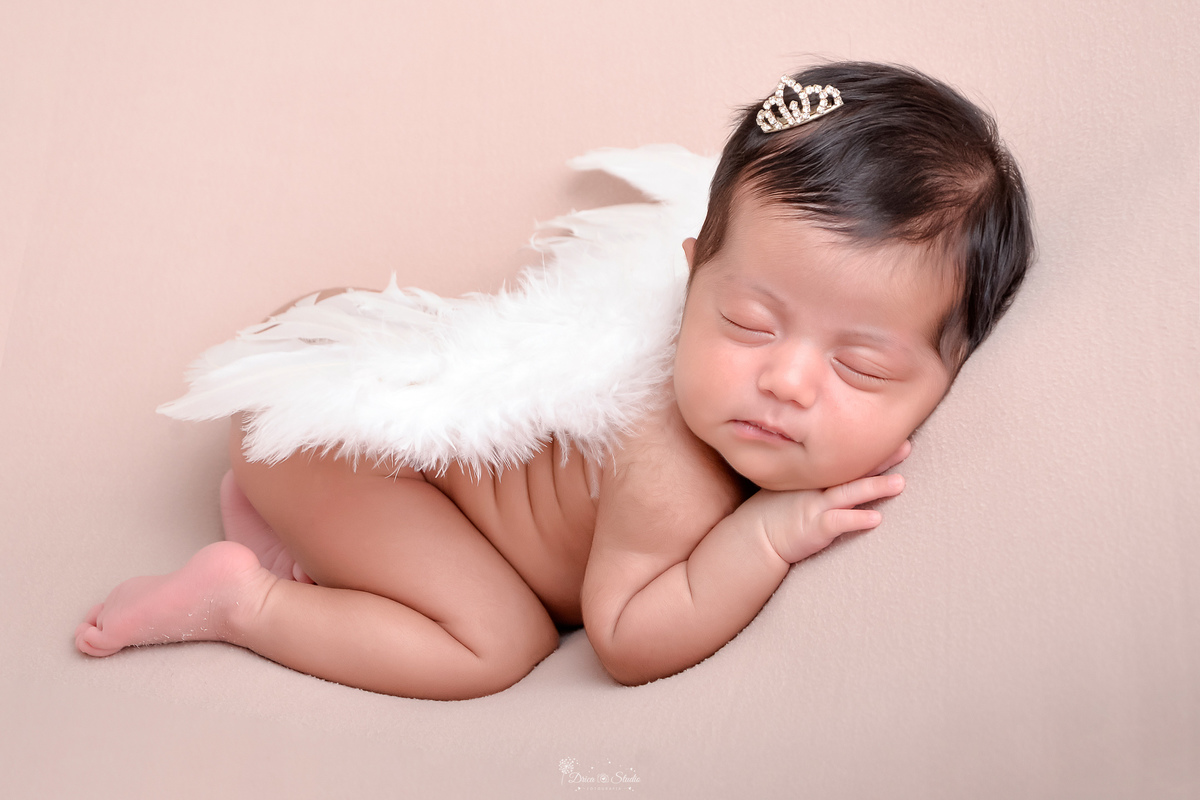 newborn - 11 dias de vida - recém nascida - menina - baby - fotografia infantil- babe deitada em tecido rosa - usando asinha de anjo e mini coroa de  princesa no cabelo - 