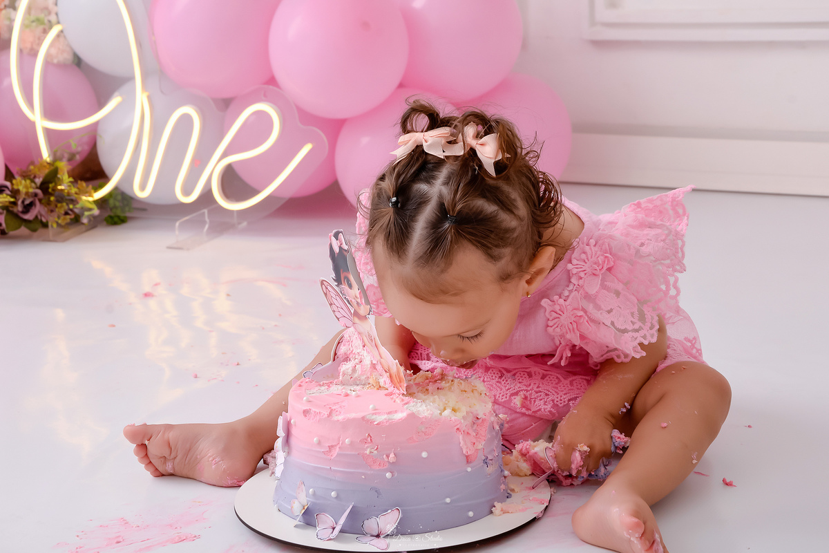 smash the cake - 1 aninho - ensaio infantil - primeiro aninho - drica studio - xinguara - pará - bebe comendo o bolo de aniversario - ao fundo balôes rosas e one de led - 