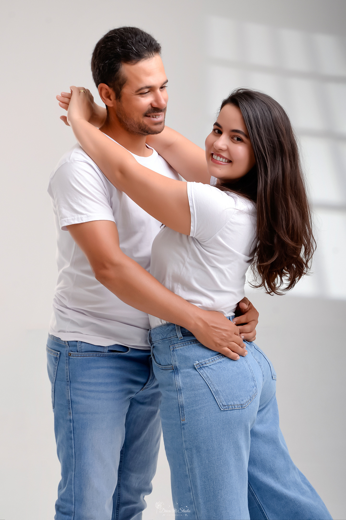 Ensaio casal - ensaio fotografico - fotos em estudio - drica studio - xinguara - pará - casal abraçados - casal usando camisa branca e calça jeans - 