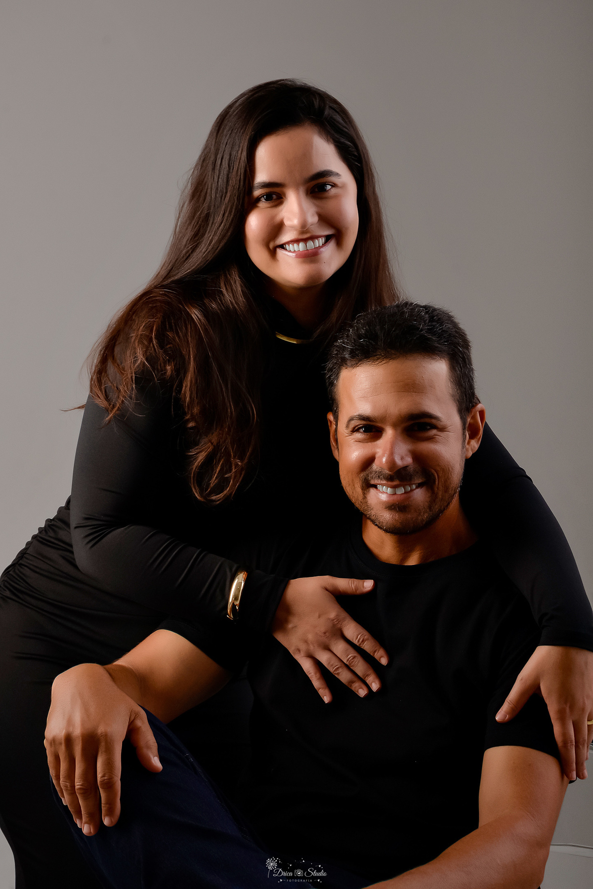 Ensaio casal - ensaio fotografico - fotos em estudio - drica studio - xinguara - pará - casal usando looks na cor preta - ela usando vestido manga longa na cor preta - ele usando camisa preta - foto em fundo sem detalhes - 