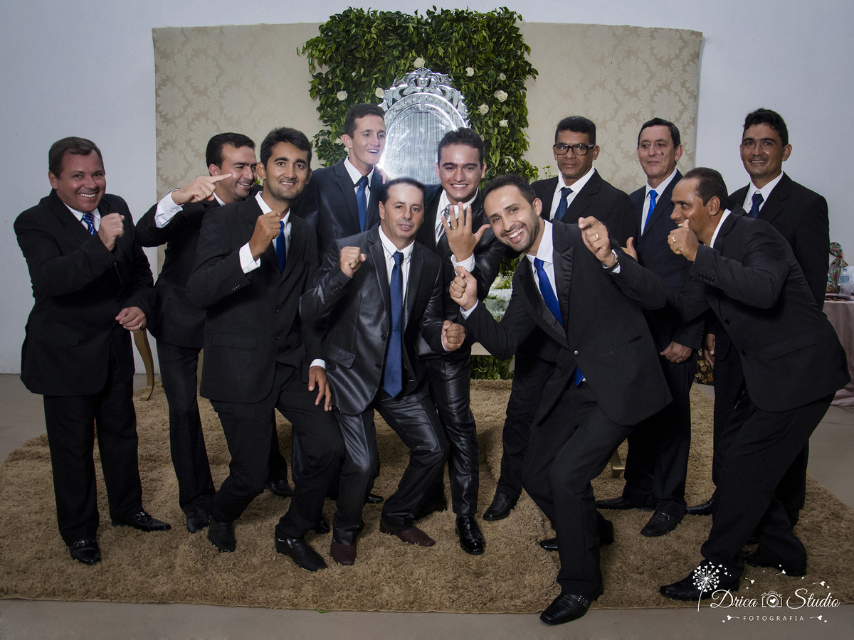 noivo vibrando em frente a messa principal  rodeado de padrinhos todos de ternos pretos.Drica Studio-Fotografias-Fotógrafo de Casamento-Xinguara-Pará- Fotografa- Casamento-Sapucaia-Pá. Padrinhos- noivo- decoração- Altenice- festa-vibrando-Padronizados