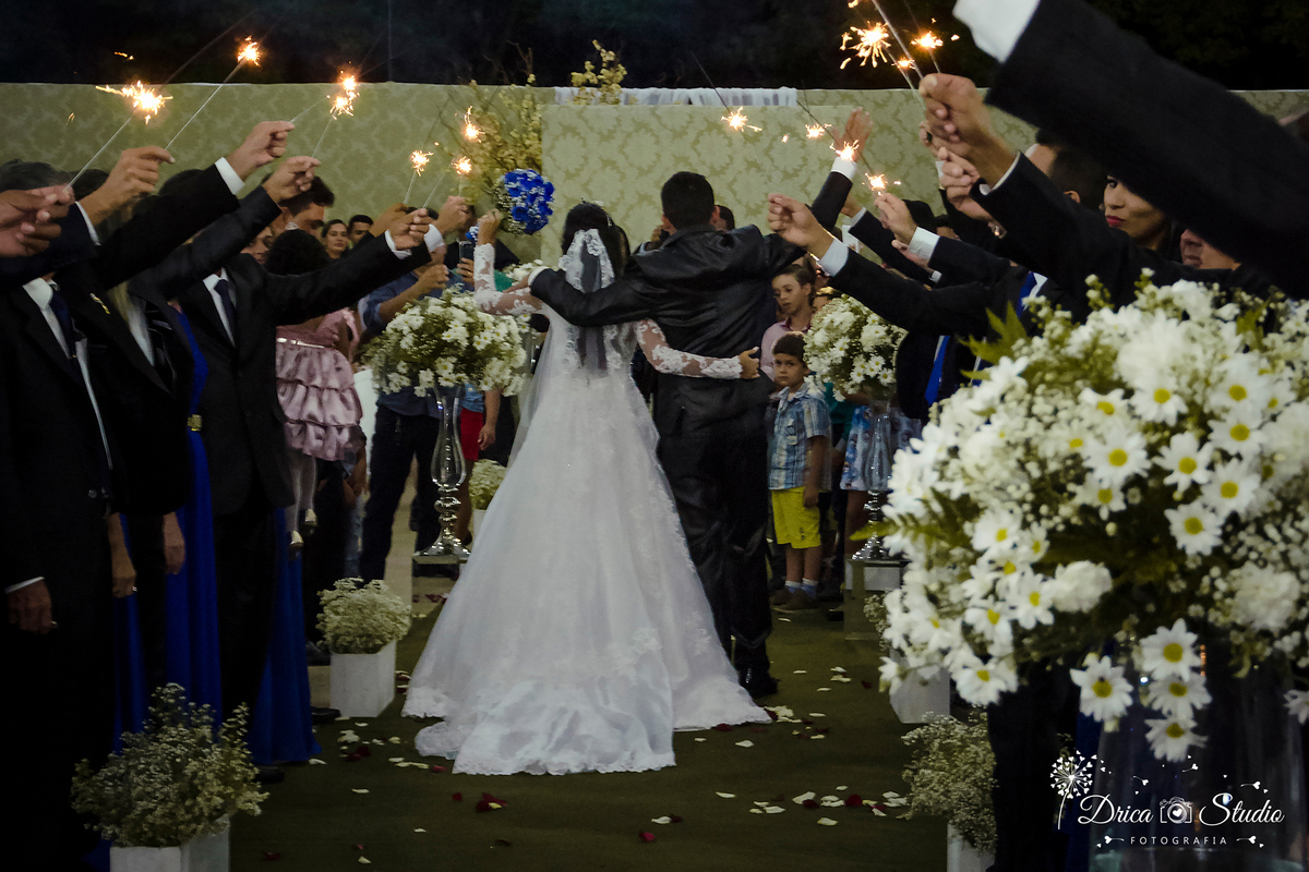 foto mostra final da cerimonia onde os padrinhos formam um arco de fogos e os noivos passam pelo meio indo embora de costa para a foto-Drica Studio-Fotografias-Fotógrafo de Casamento-Xinguara-Pará- Fotografa-Casamento-Sapucaia-Pá.Passarela.