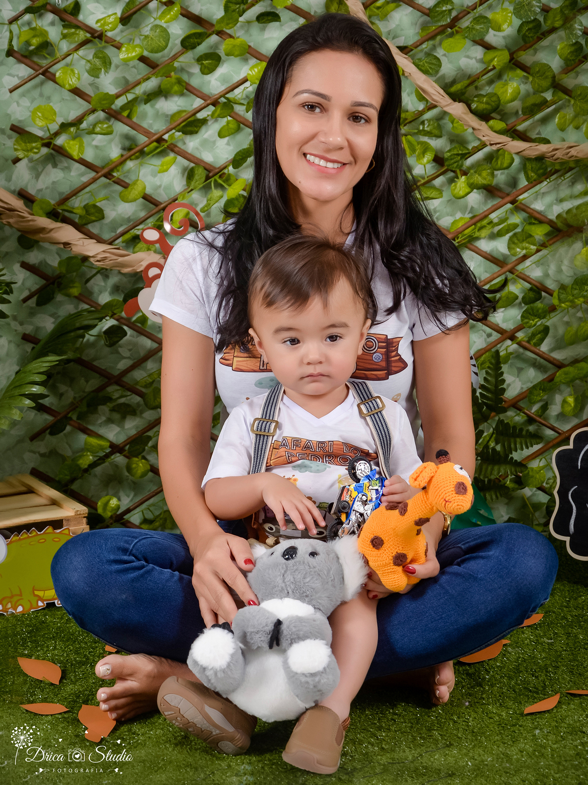 foto da mamãe com seu bebe sentado no seu colo antes do Smash ambos estão com camisa mãe e filho, tema safári. fundo verde senário artificial.Fotografa Infantil- Fotógrafo em Xinguara-Fotógrafo de Criança- Ensaio Infantil- Acompanhamento de bebê- Safári.