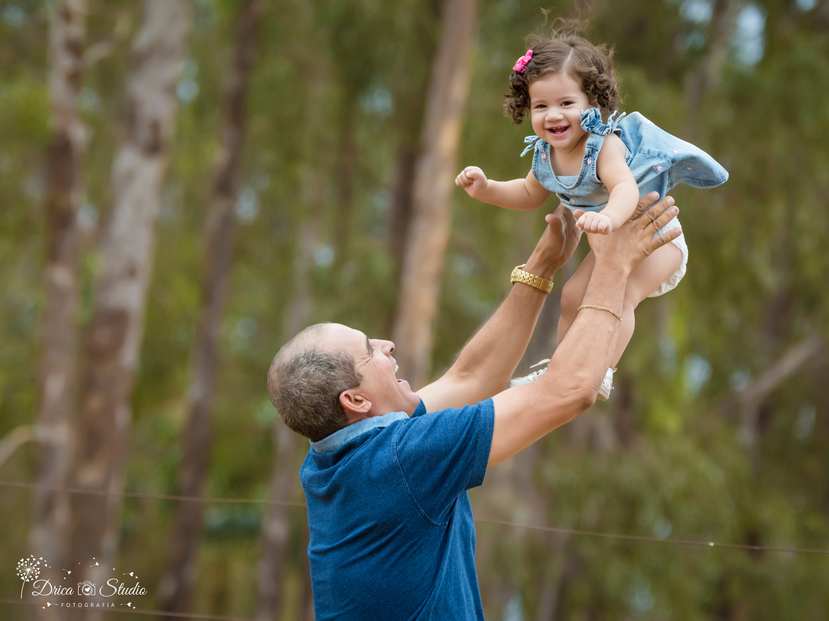Ensaio- Valentina-com o papai- jogando ela para o alto- brincadeira-eucalipto-vestido jeans- Xinguara- Pará- ensaio infantil- ensaio externo- ensaio de família- grama- Fotógrafa- Drica Studio- Fotografia de família- fotografa em Xinguara-Smash The Cake.