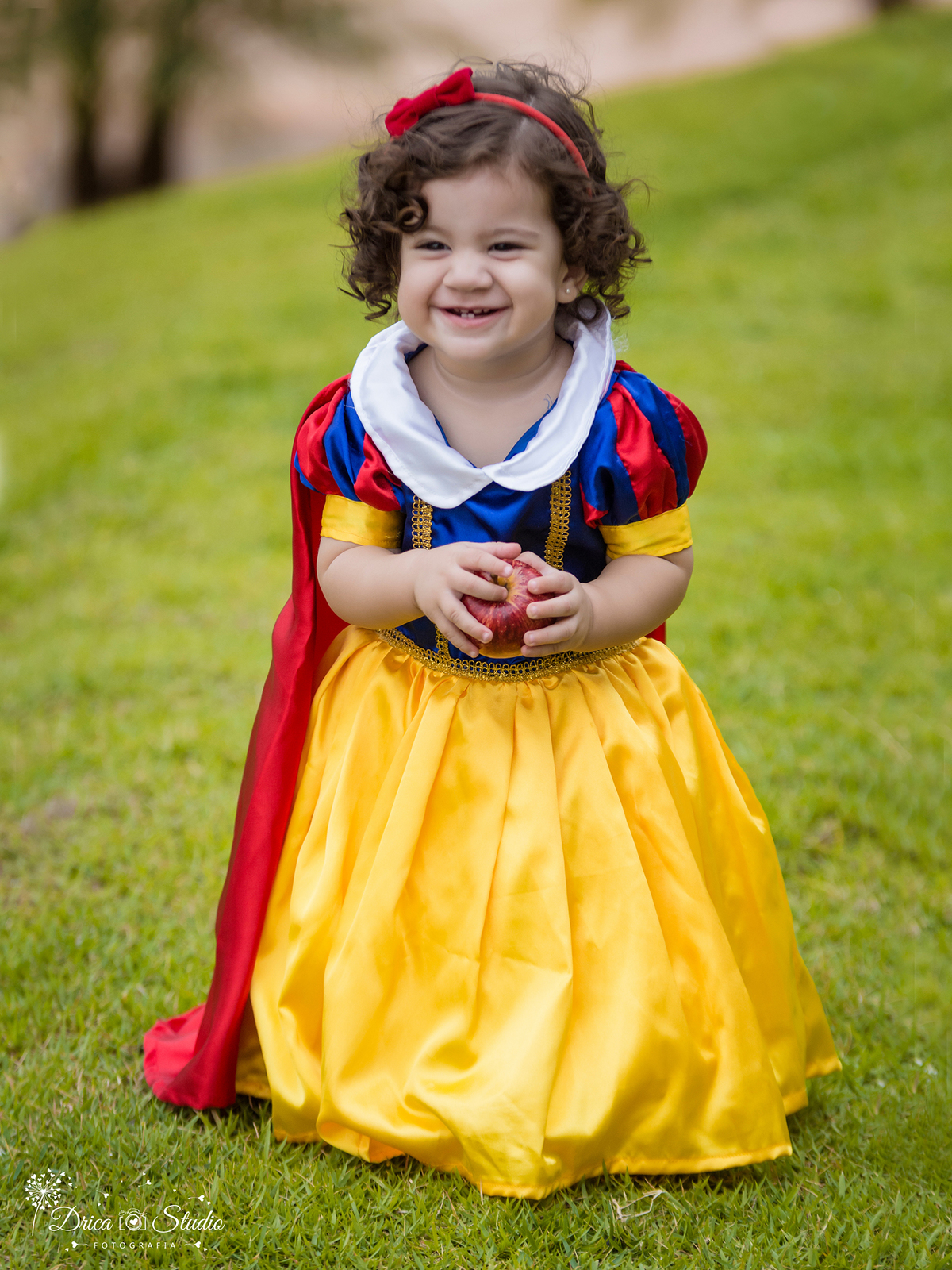  Smash the Cake-Branca de Neve- sorrindo-com a maçã-Xinguara- Pará- ensaio infantil- ensaio externo- ensaio de família- contos de fada- bolo- amarelo- Fotógrafa- Drica Studio- Fotografia de família.