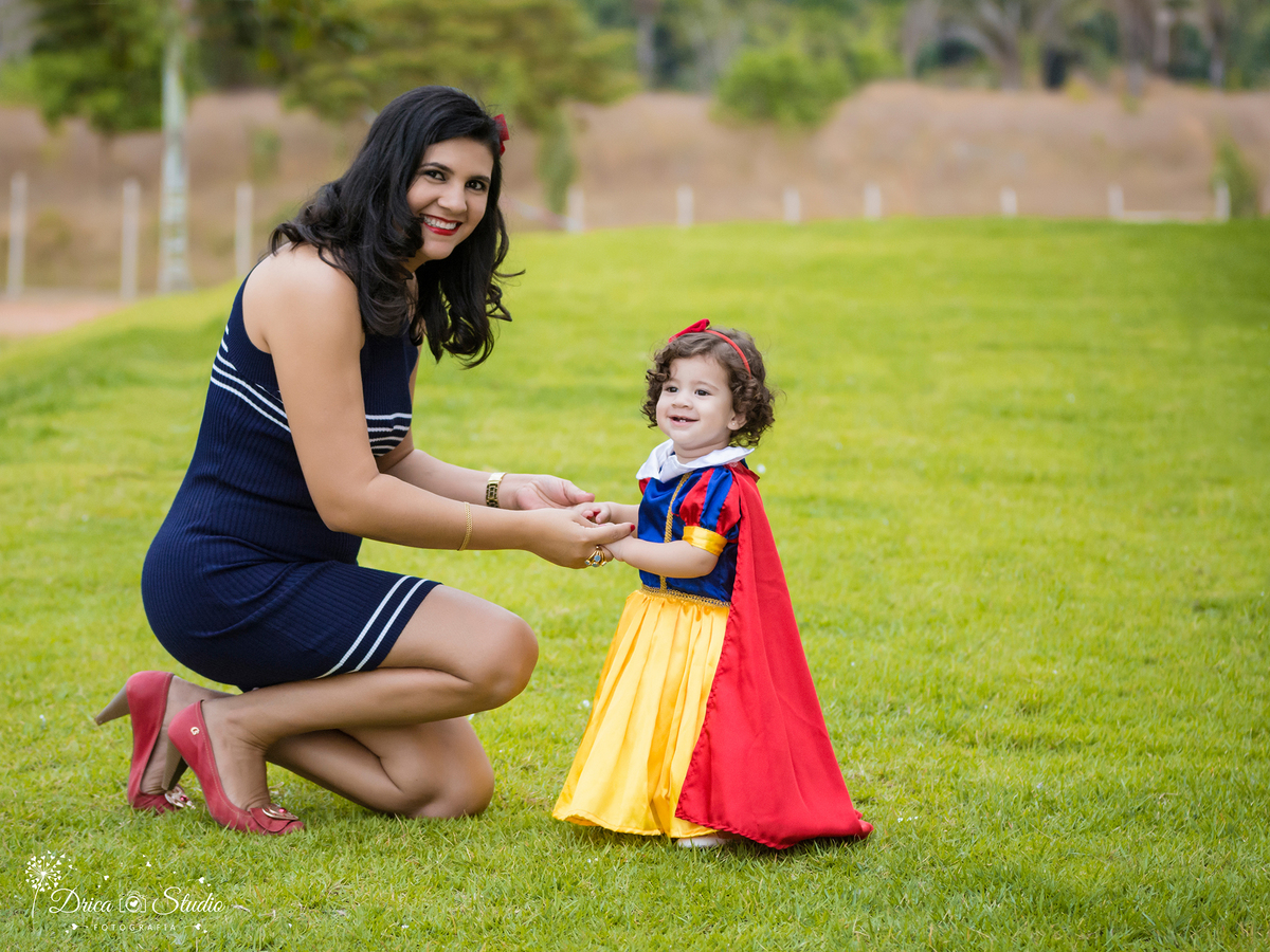  Smash the Cake-Branca de Neve- sorrindo- mãos dada com a  mãe -Xinguara- Pará- ensaio infantil- ensaio externo- ensaio de família- contos de fada- grama verde- amarelo- Fotógrafa- Drica Studio- Fotografia de família- fotografa em Xinguara.