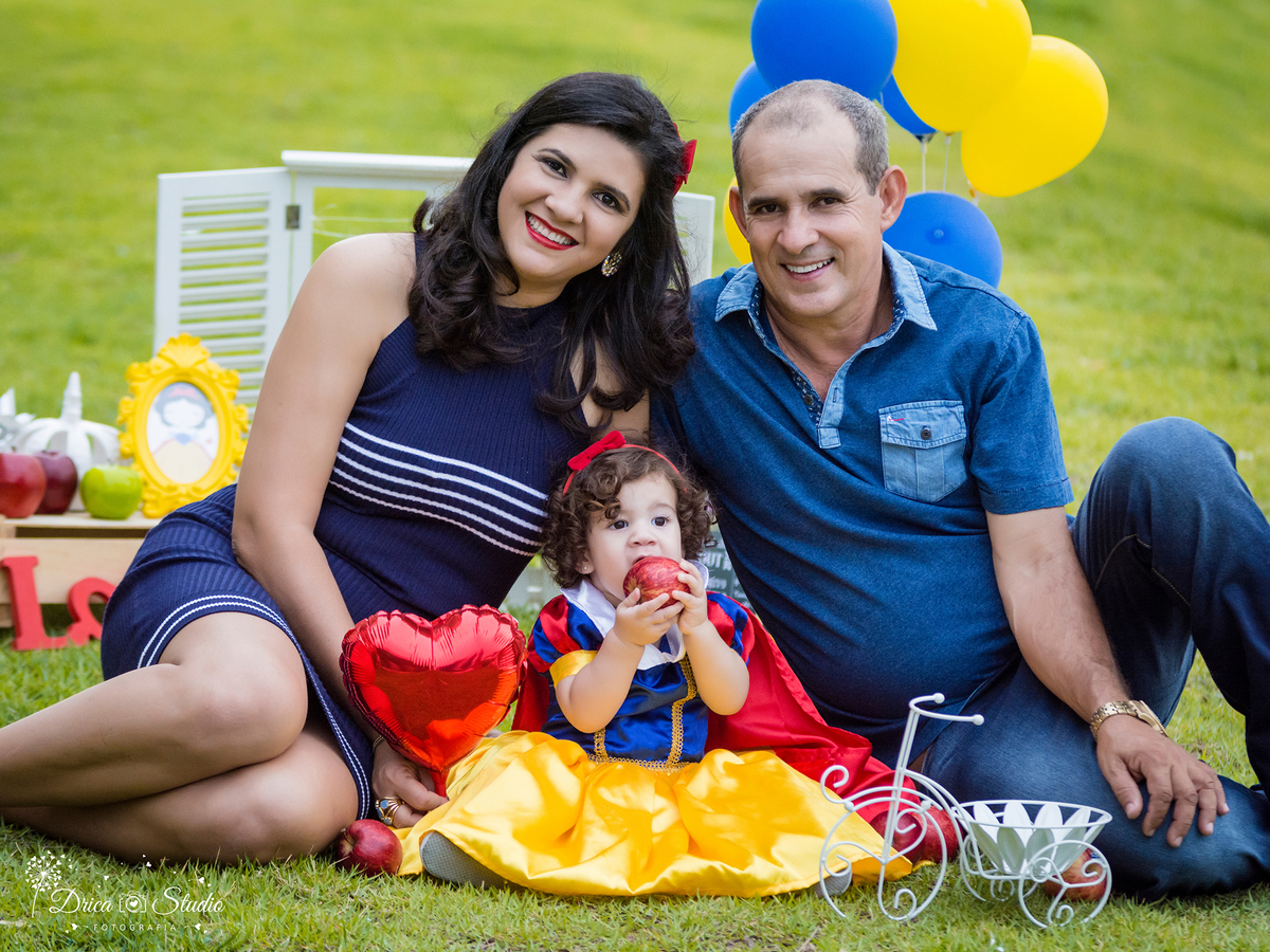  Smash the Cake- Branca de Neve- sorrindo-mordendo a maçã- Pai e Mãe- Xinguara- Pará- ensaio infantil- ensaio externo- ensaio de família- contos de fada- grama verde- amarelo- Fotógrafa- Drica Studio- Fotografia de família- fotografa em Xinguara.. 