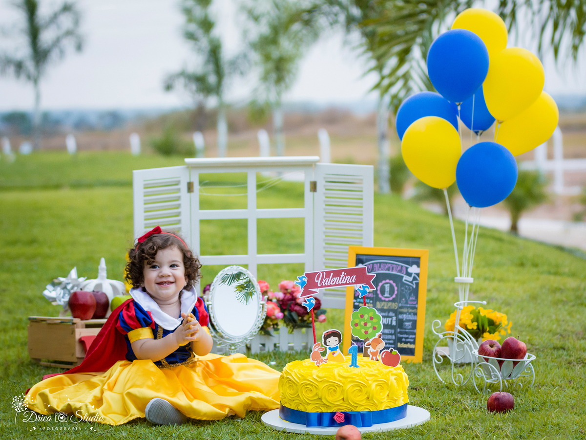  Smash the Cake- Branca de Neve- sorrindo-com bolo -Xinguara- Pará- ensaio infantil- ensaio externo- ensaio de família- contos de fada- grama verde- amarelo- Fotógrafa- Drica Studio- Fotografia de família- fotografa em Xinguara- cenário- lindo. 