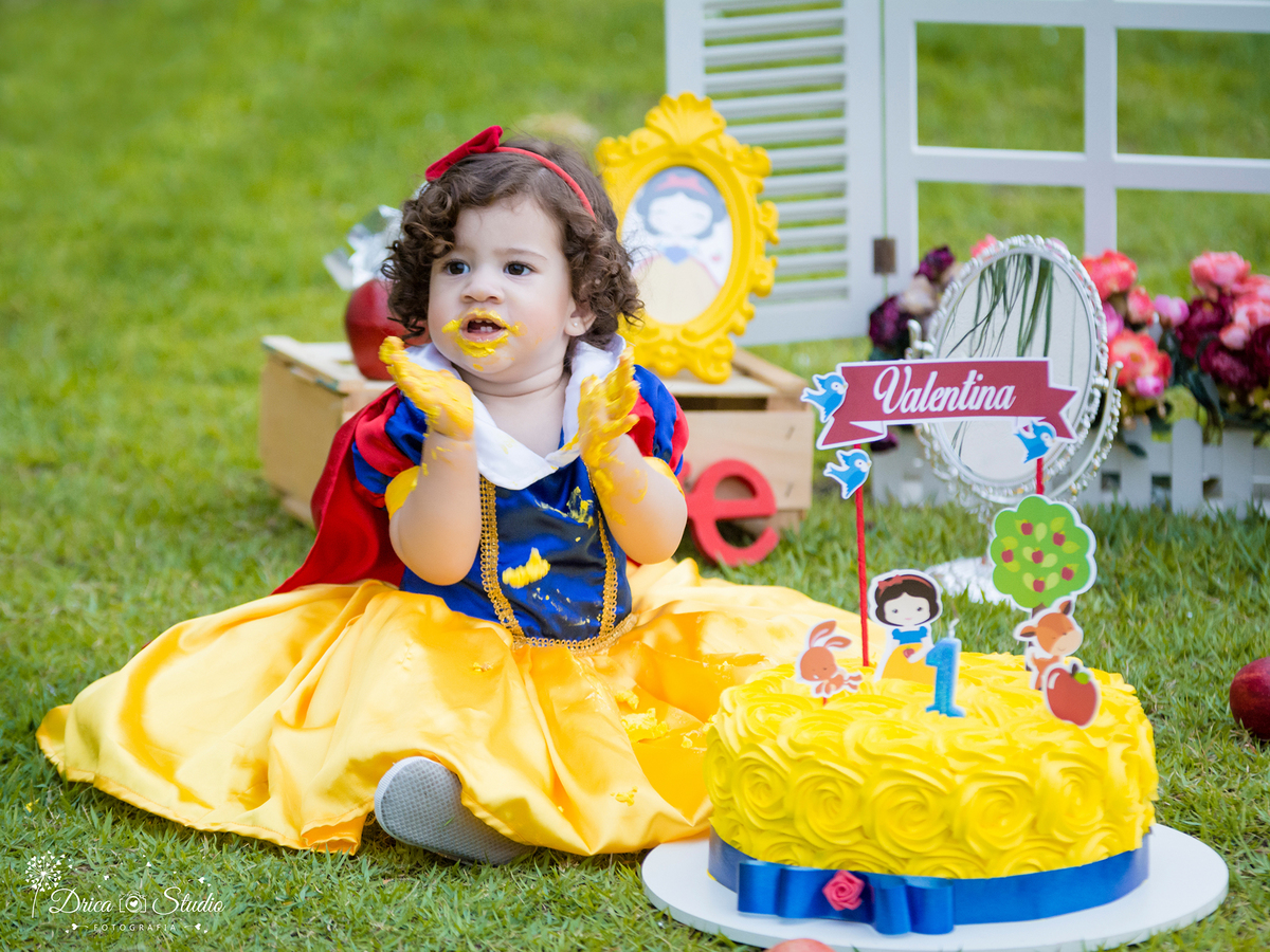  Smash the Cake- Branca de Neve- sorrindo-batendo palminhas -Xinguara- Pará- ensaio infantil- ensaio externo- ensaio de família- contos de fada- grama verde- amarelo- Fotógrafa- Drica Studio- Fotografia de família- fotografa em Xinguara- cenário- lindo. 