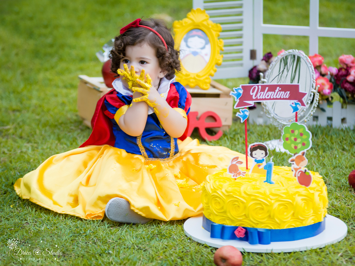  Smash the Cake- Branca de Neve- Valentina-comendo o bolo -Xinguara- Pará- ensaio infantil- ensaio externo- ensaio de família- contos de fada- grama verde- amarelo- Fotógrafa- Drica Studio- Fotografia de família- fotografa em Xinguara- cenário- lindo. 